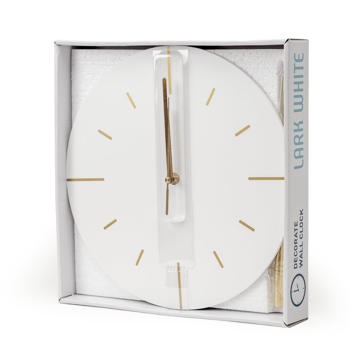 Eine weiße und goldene Wanduhr mit Zeigern in einer geöffneten Verpackung.