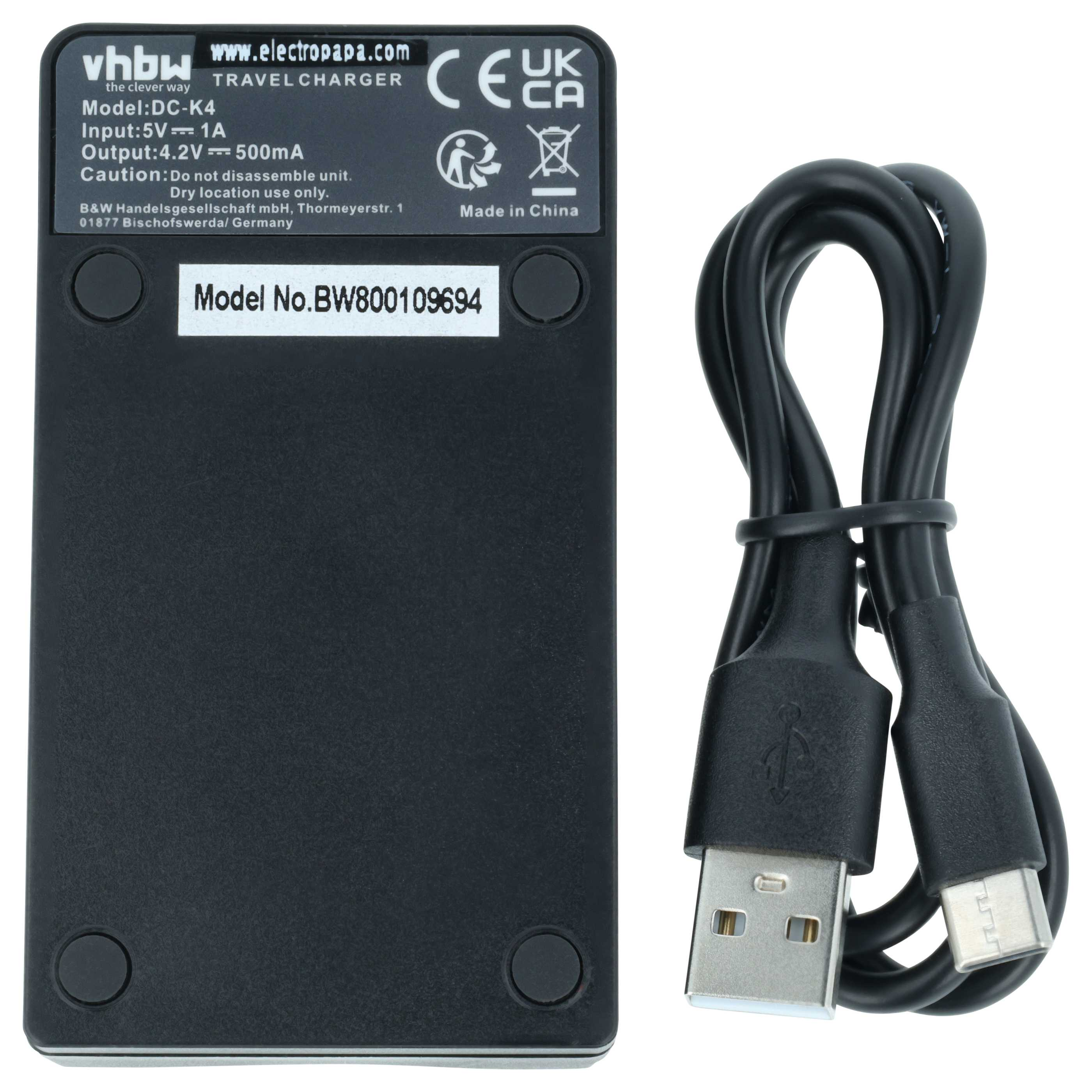 Ein schwarzes Reise-Ladegerät mit Modellinformationen und einem schwarzen USB-Kabel daneben.