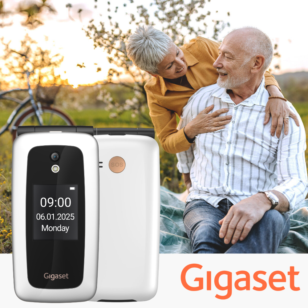 Ein älteres Paar sitzt draußen, im Vordergrund ein weißes Gigaset-Klapphandy mit Uhrzeit und Datum.