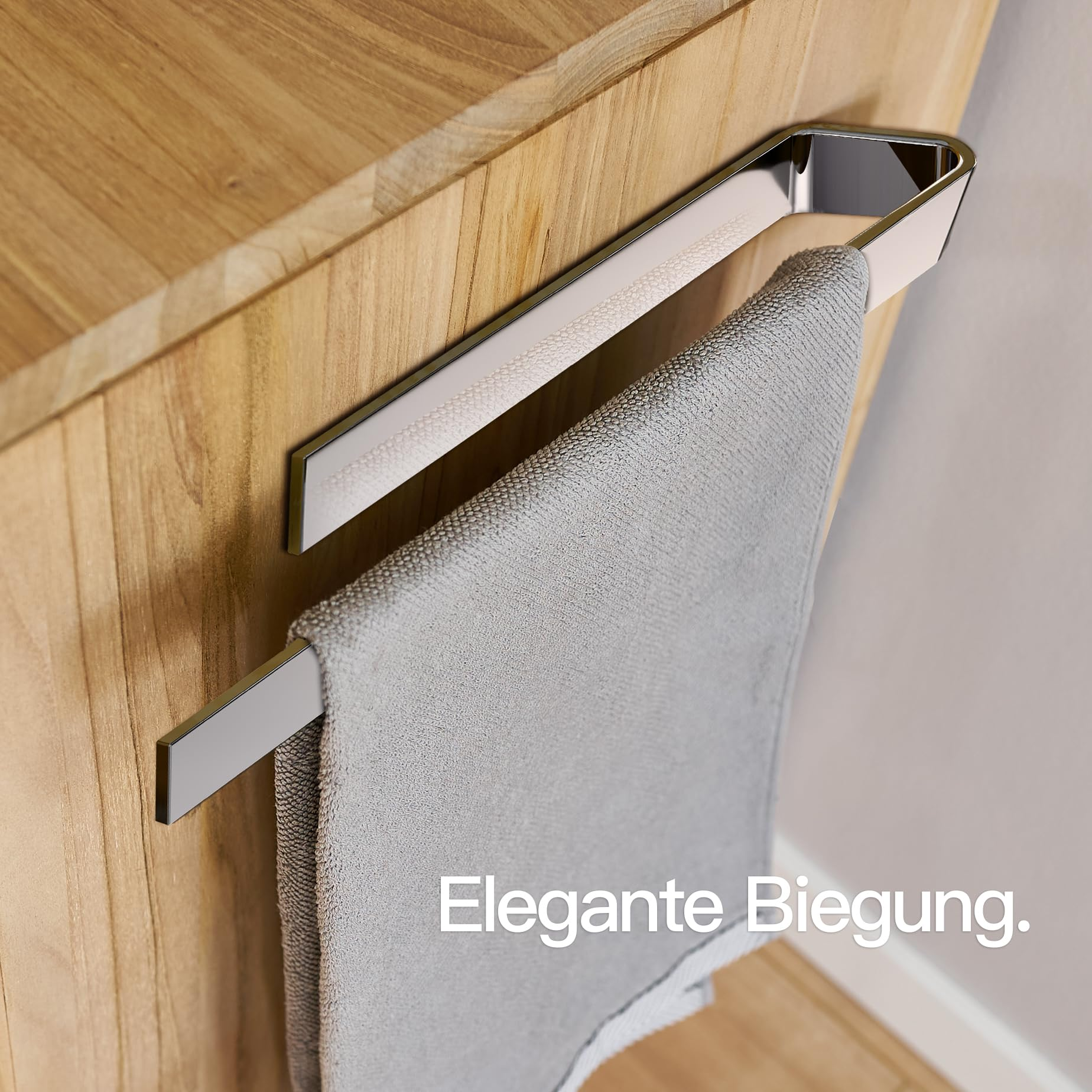 Ein glänzender, verchromter Handtuchhalter aus Metall ist an einem Holzschrank montiert, mit einem grauen Handtuch.