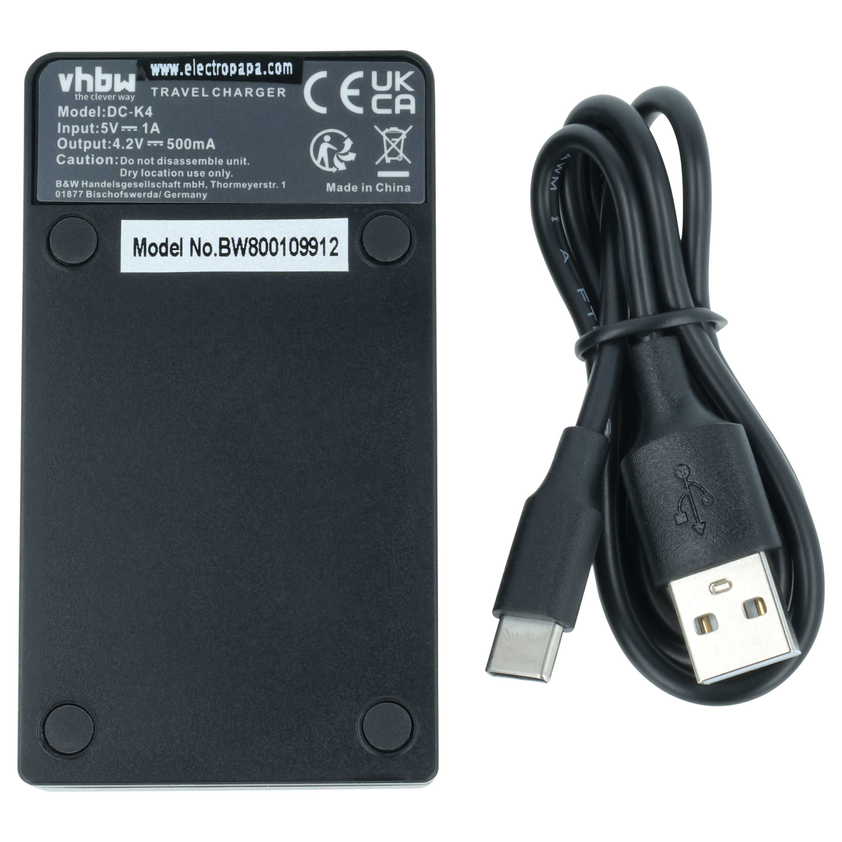 Schwarzes Reise-Ladegerät mit weißem Etikett und einem gebündelten schwarzen USB-Kabel auf weißem Hintergrund.