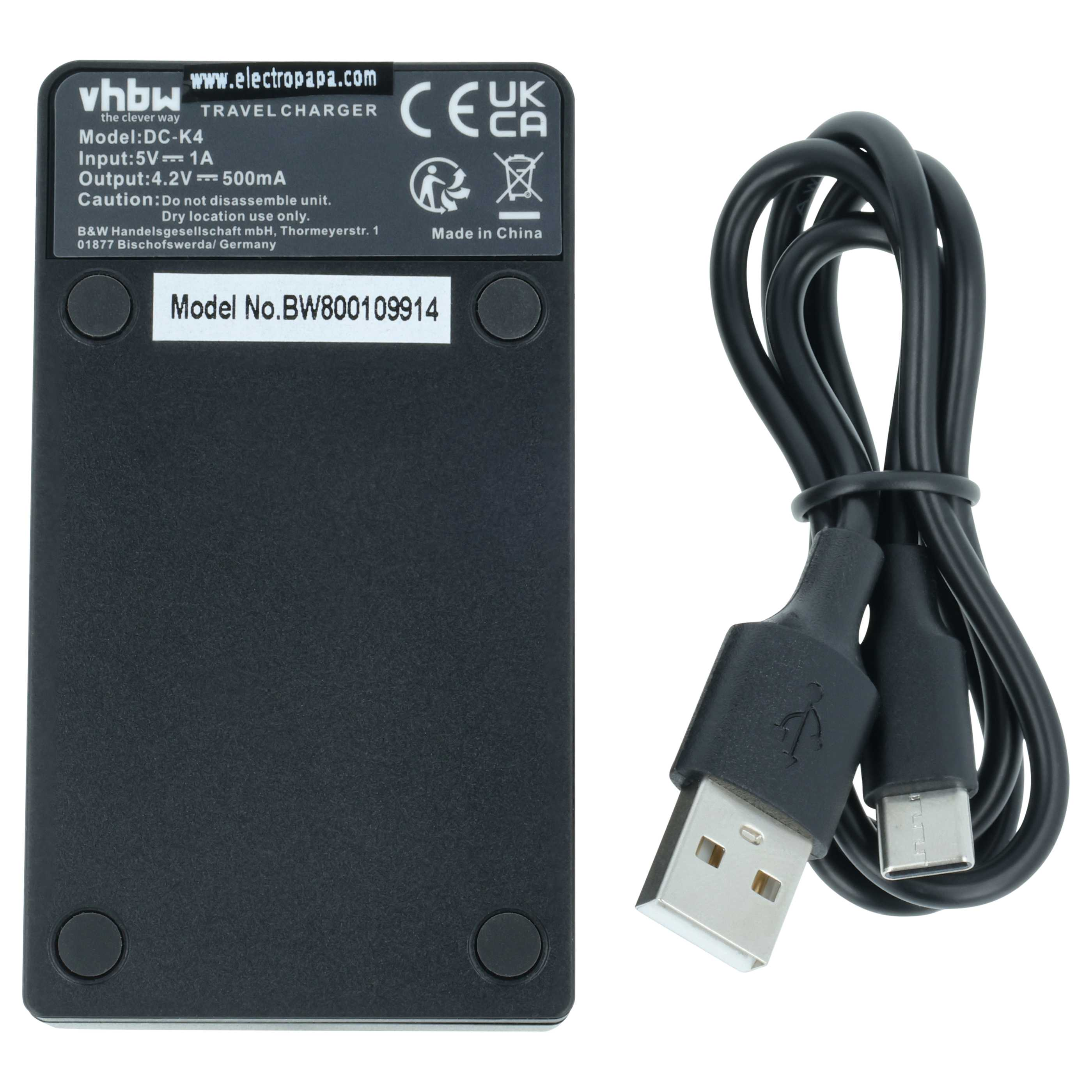 Ein schwarzes Reiseladegerät mit technischen Daten und daneben ein zusammengerolltes schwarzes USB-Kabel.