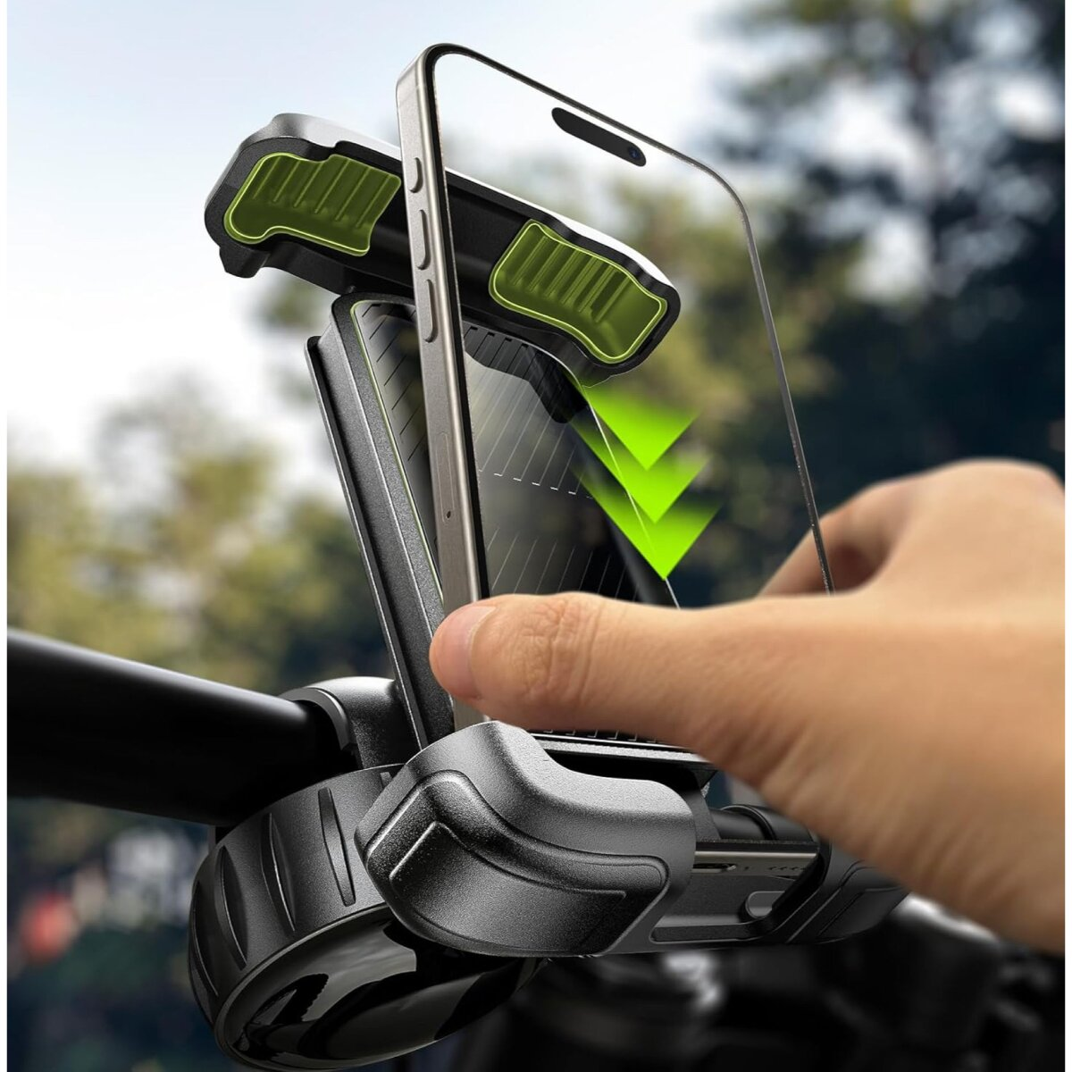 Eine Hand montiert ein Smartphone in eine schwarz-grüne Fahrradlenker-Handyhalterung im Freien.