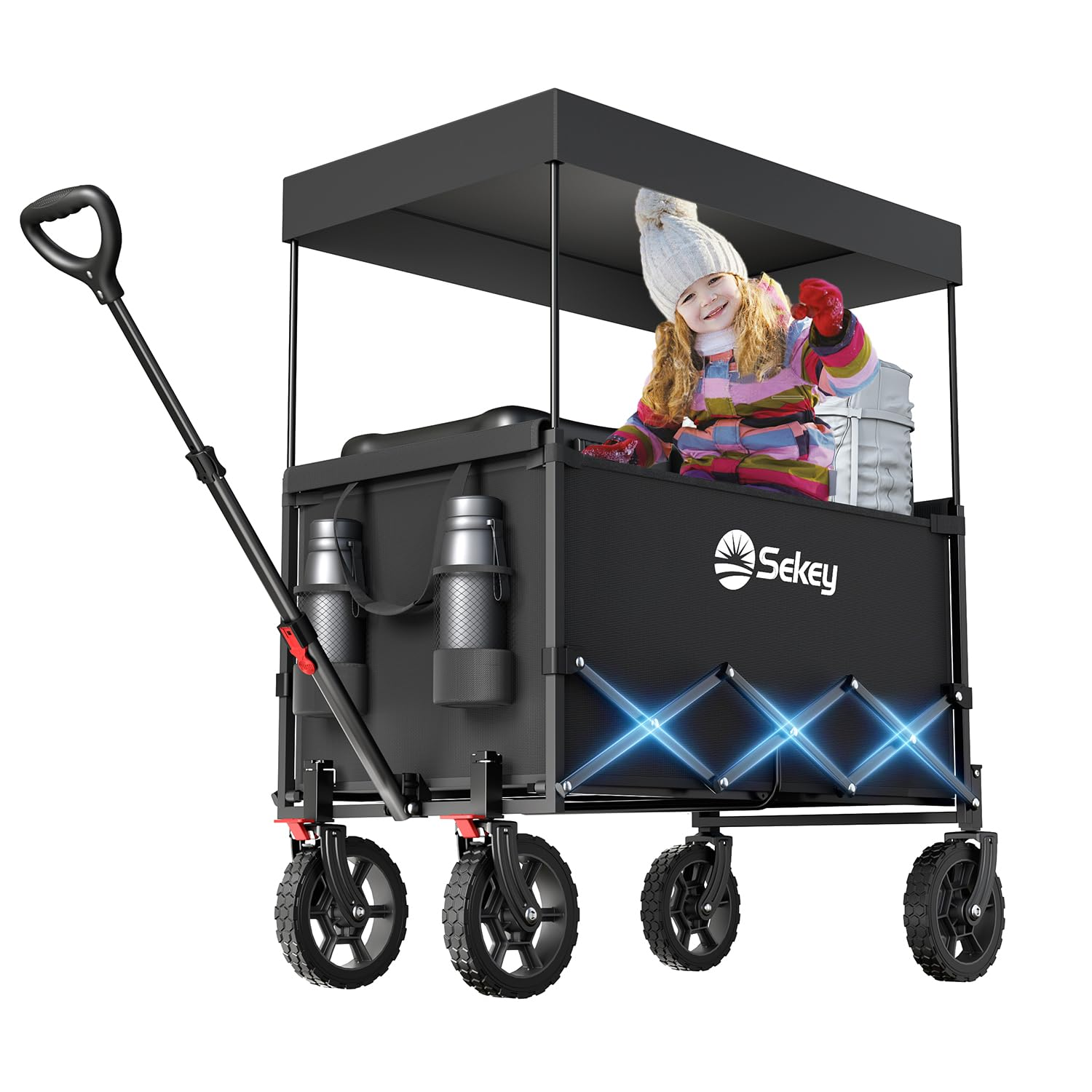 Un chariot pliant noir avec un auvent, deux porte-bouteilles et un enfant assis à l'intérieur sur fond blanc.