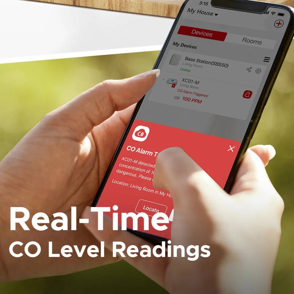 Eine Hand hält ein Smartphone mit einer Smart-Home-App, die einen Kohlenmonoxid-Alarm anzeigt.