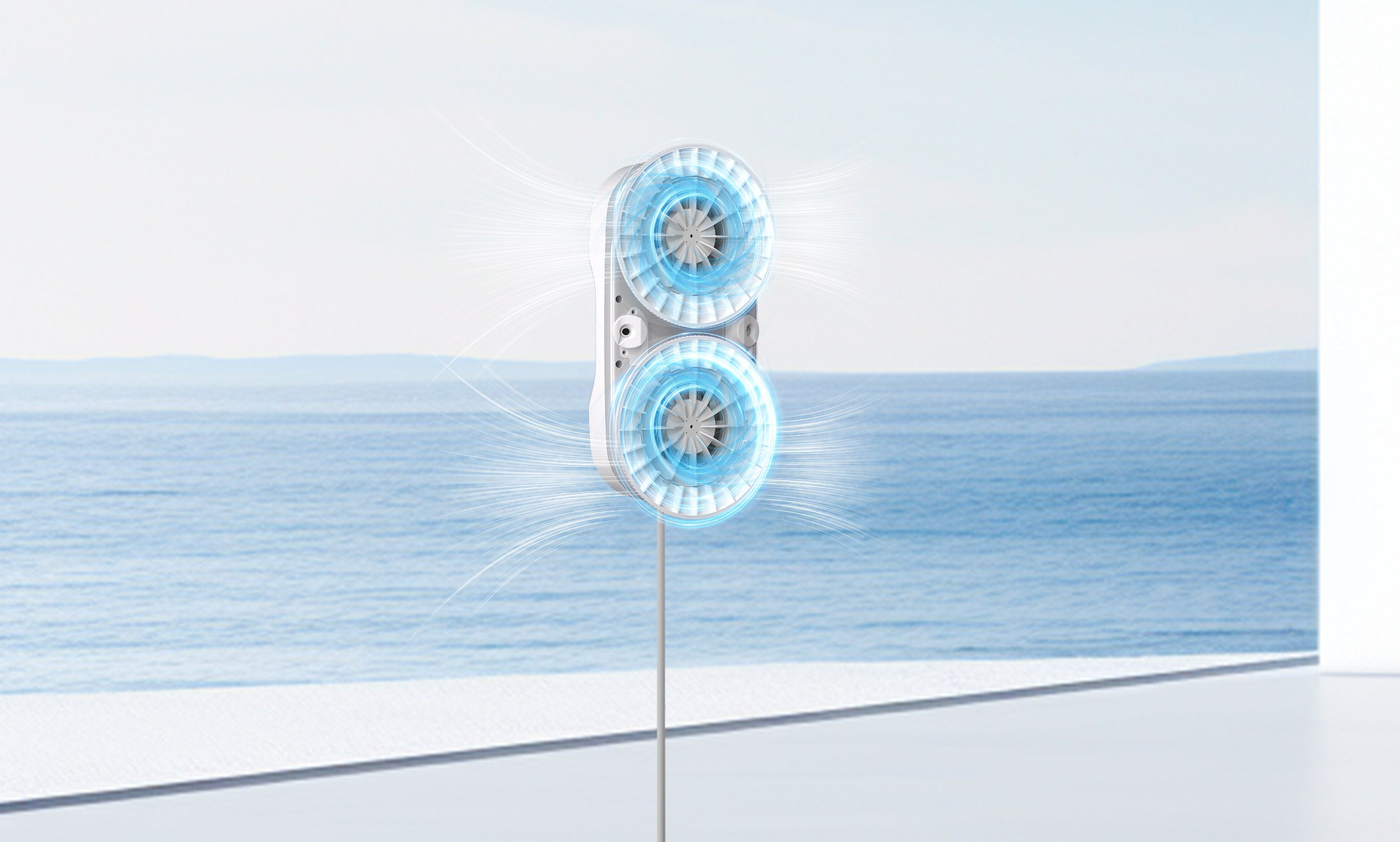A white, columnar household appliance with two rotating fans set against an ocean backdrop.