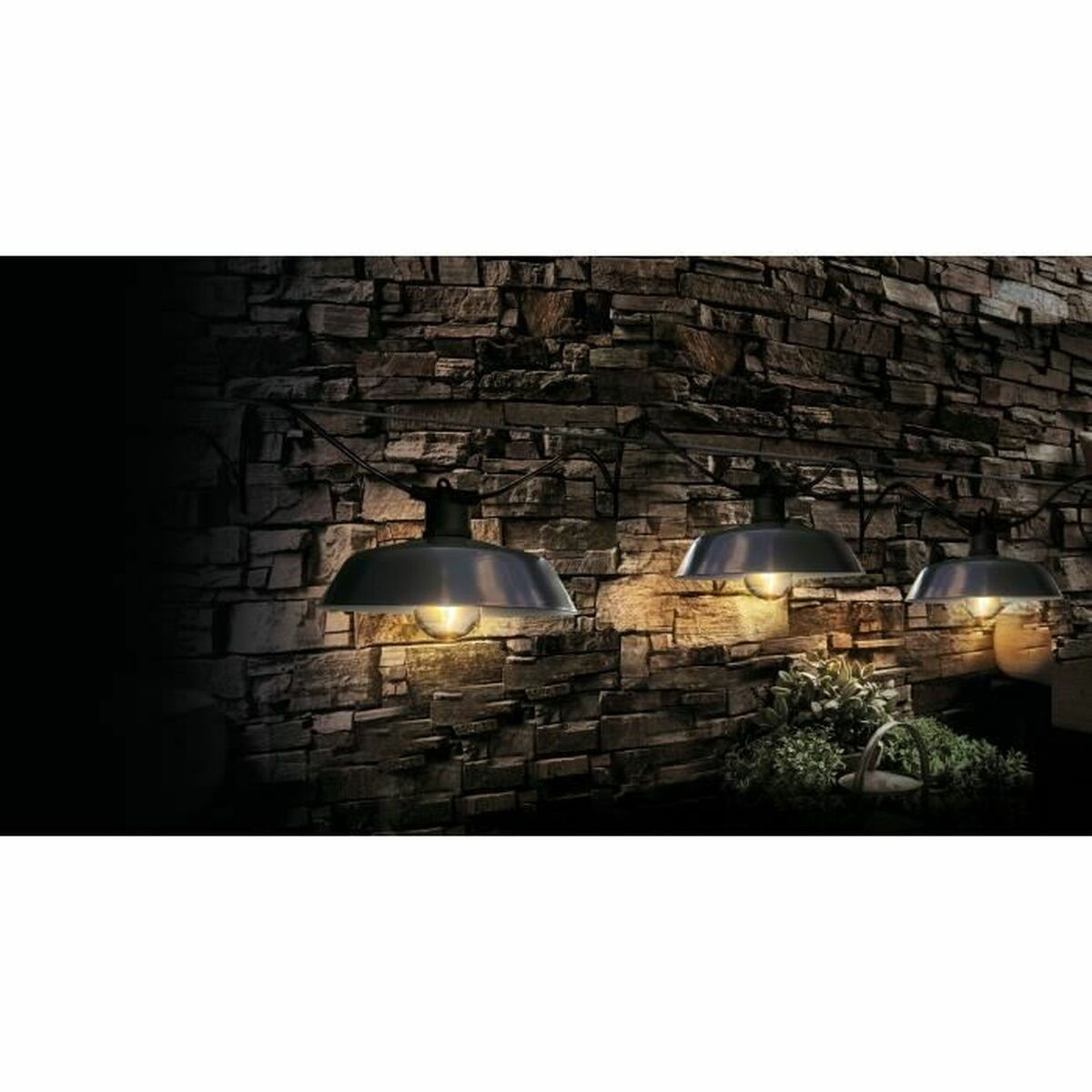 Drei schwarze Außenleuchten an einer Steinwand mit warmem Licht.