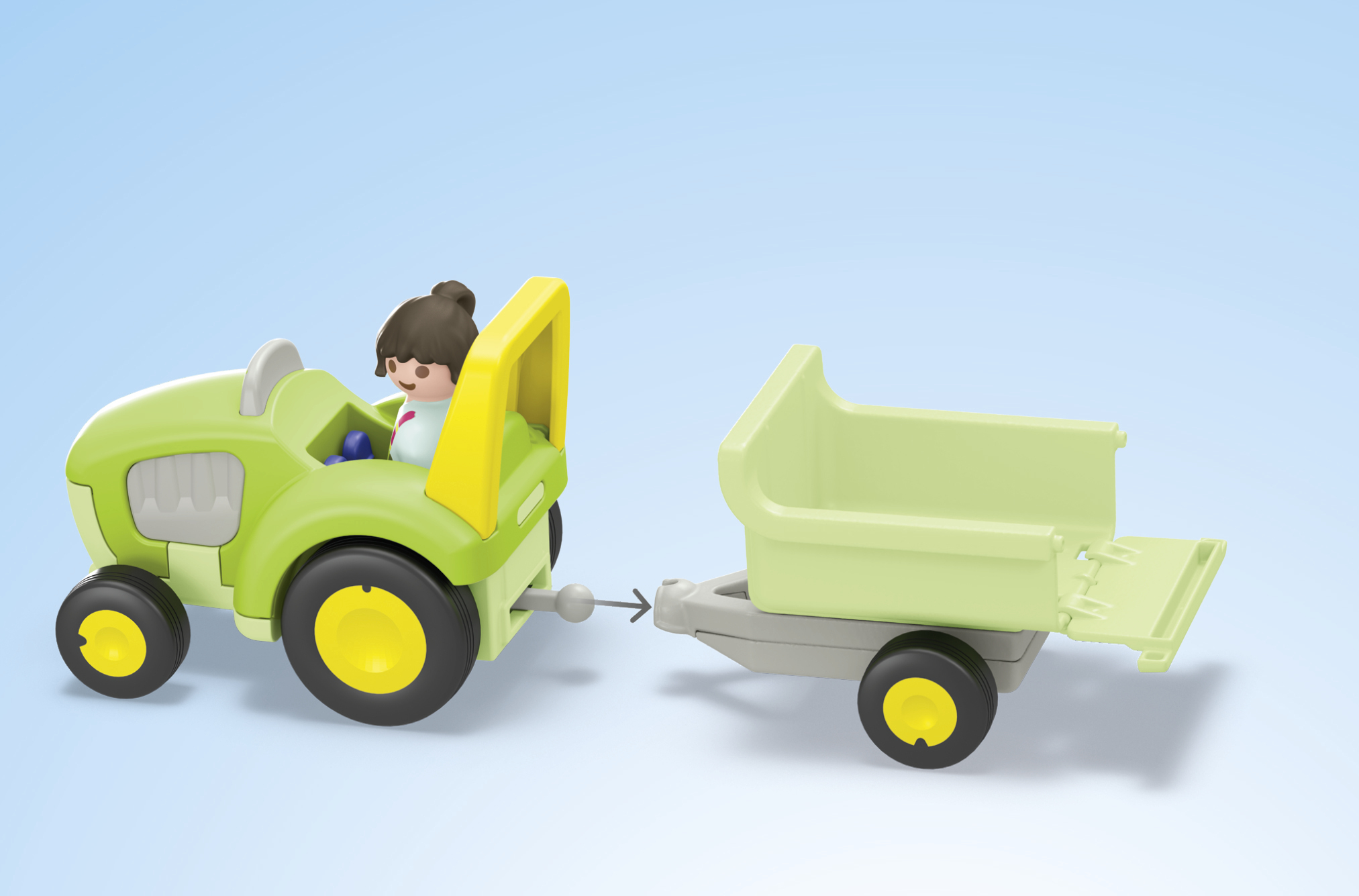 A green toy tractor with a trailer and a small figurine against a blue background.