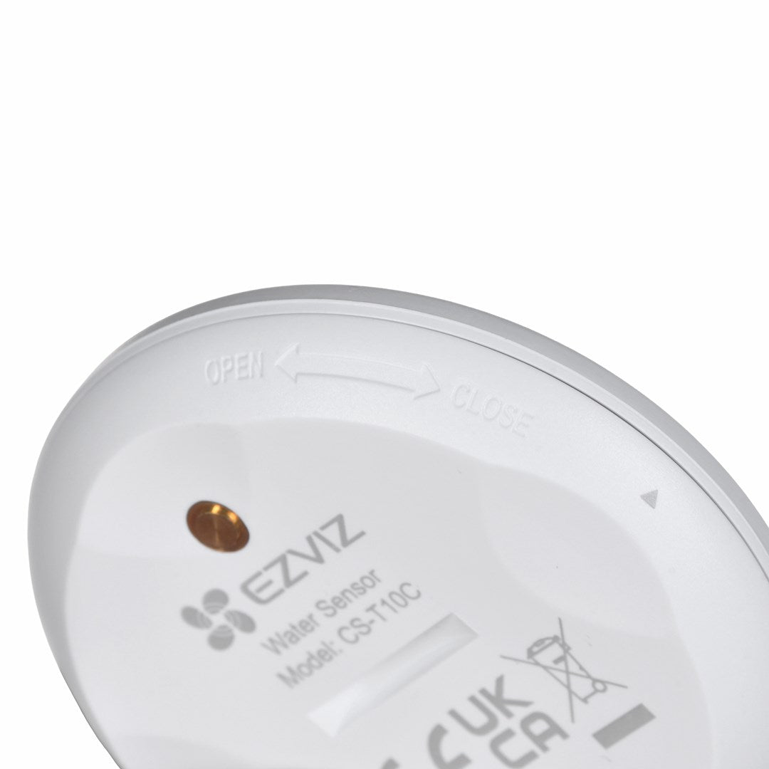Primo piano del retro di un sensore d'acqua bianco EZVIZ CS-T10C con frecce.