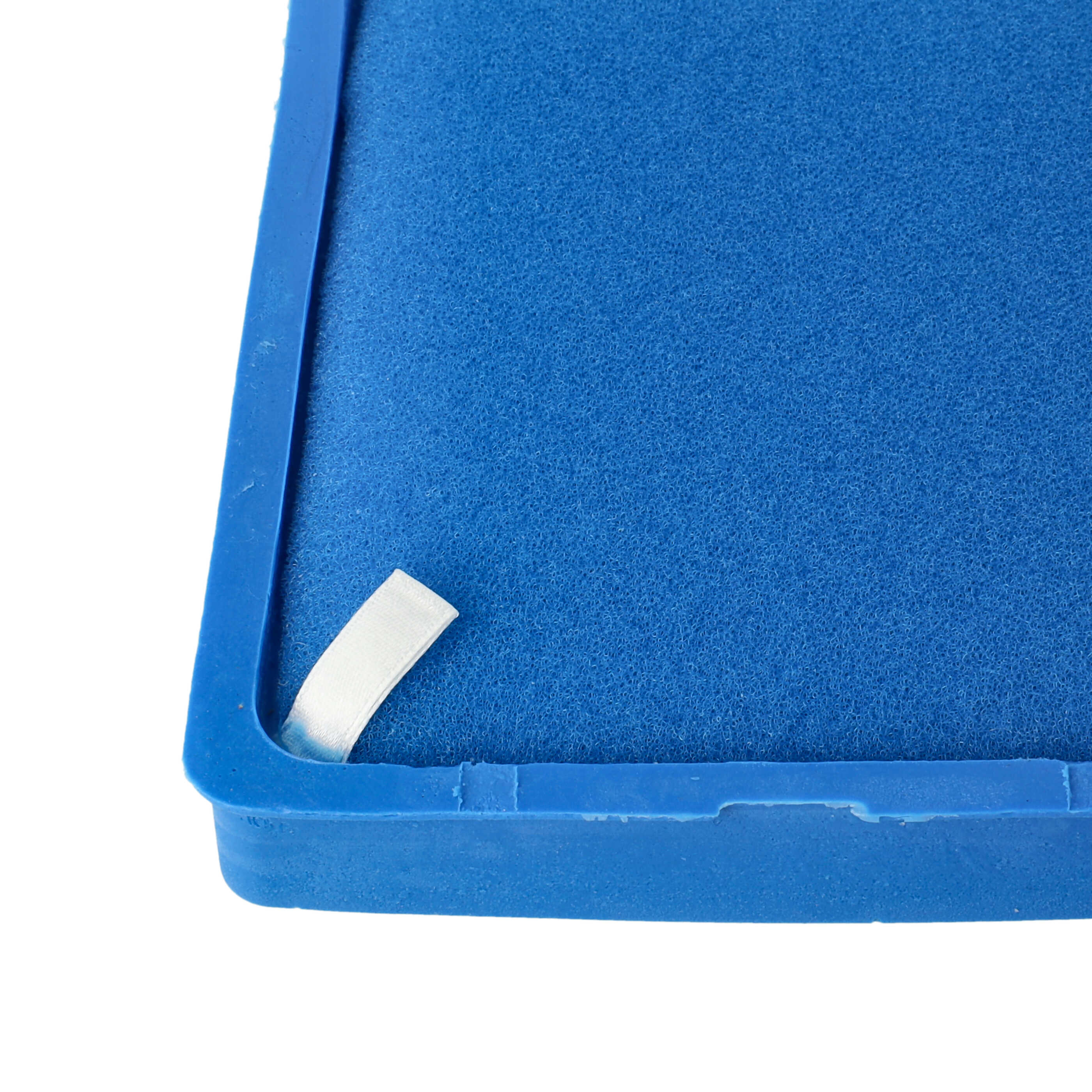 Ein blauer Luftfilter aus Schaumstoff mit einem kleinen weißen Stoffstreifen in der Ecke.