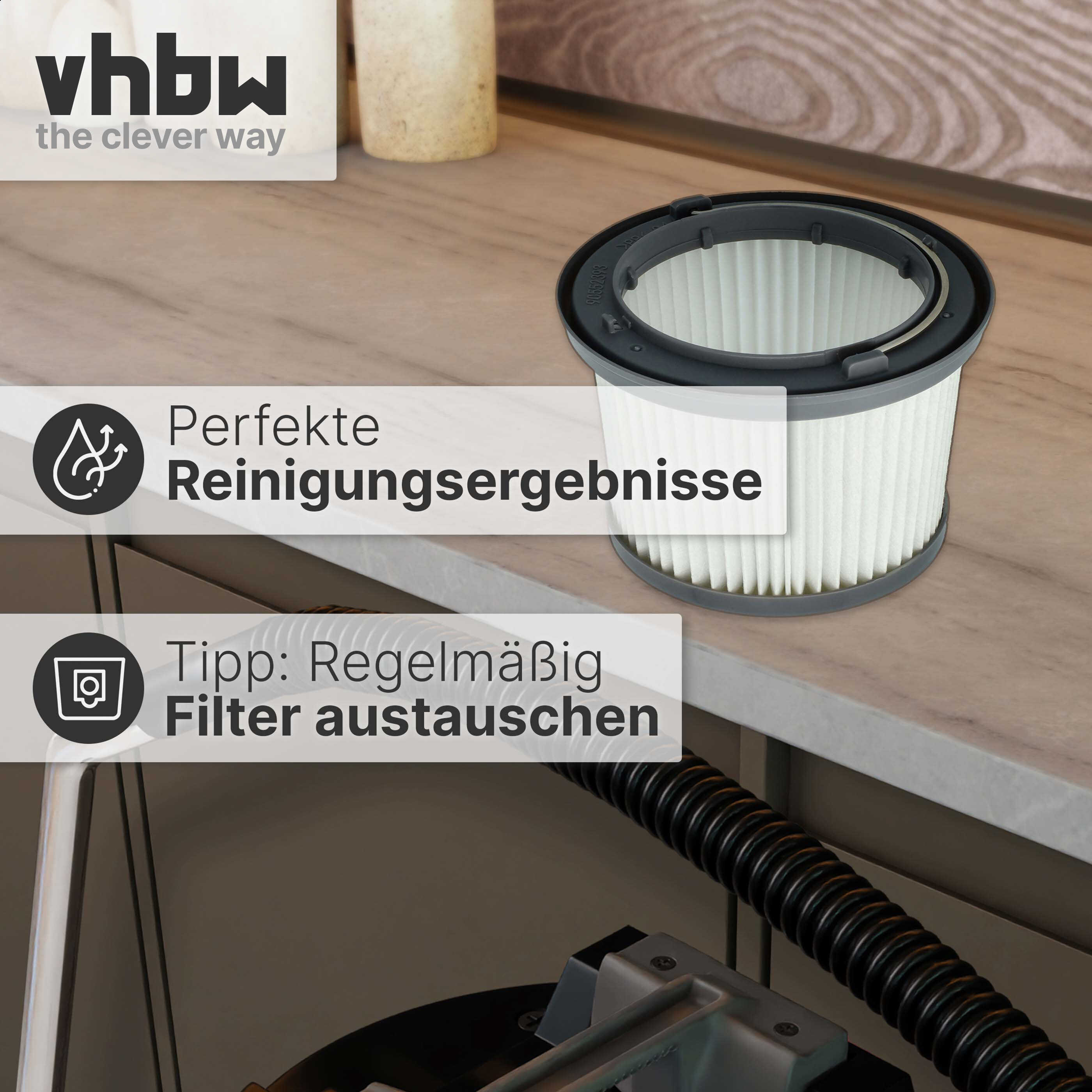 Ein zylindrischer Staubsaugerfilter liegt auf einer Holzarbeitsplatte neben einem schwarzen Schlauch.