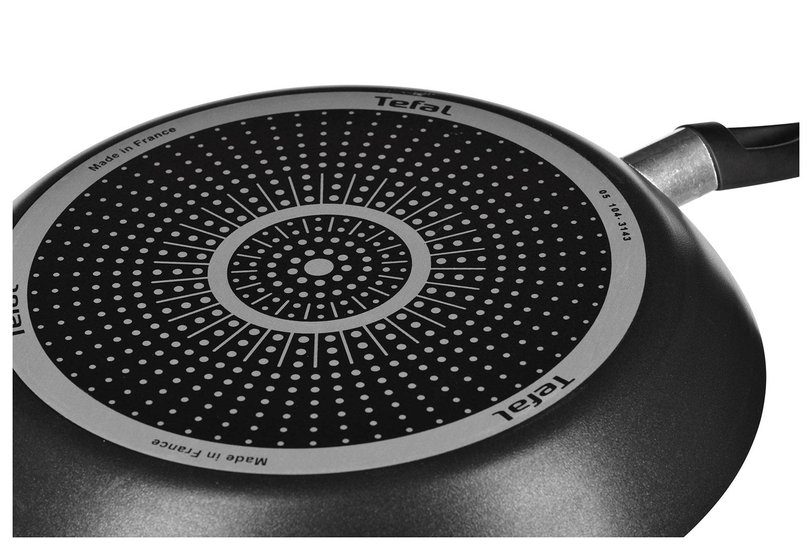 Widok spodu patelni Tefal z podstawą indukcyjną w koncentryczne kropki i logo.