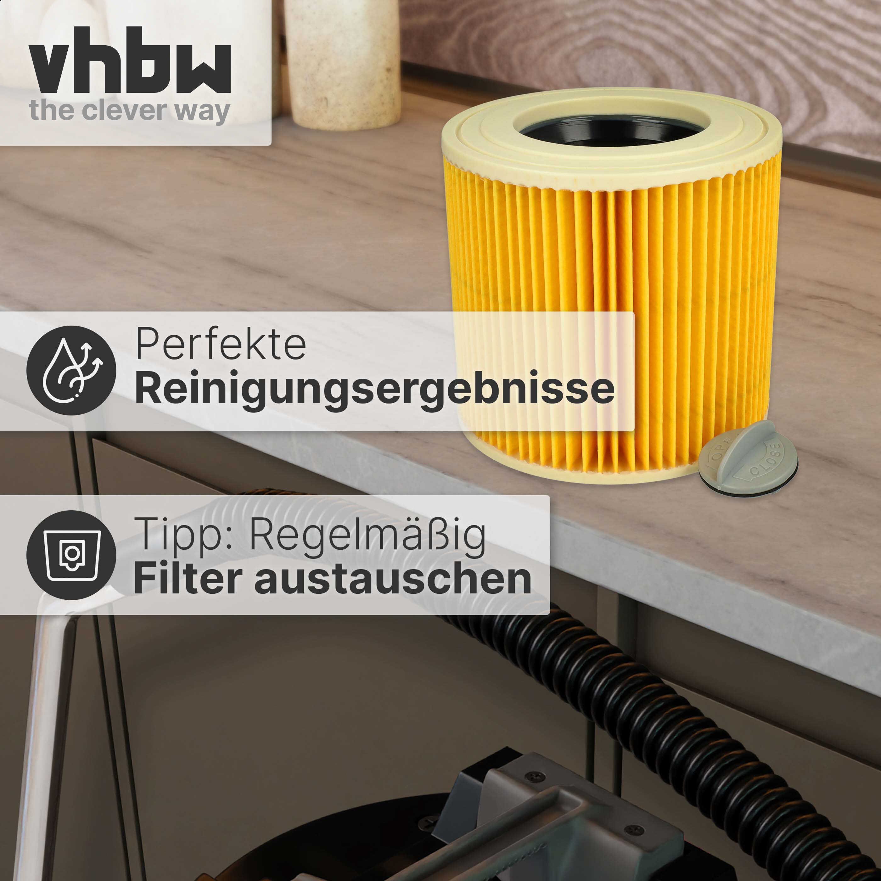 Ein gelber zylindrischer Staubsaugerfilter auf einer Theke mit einem schwarzen Schlauch.