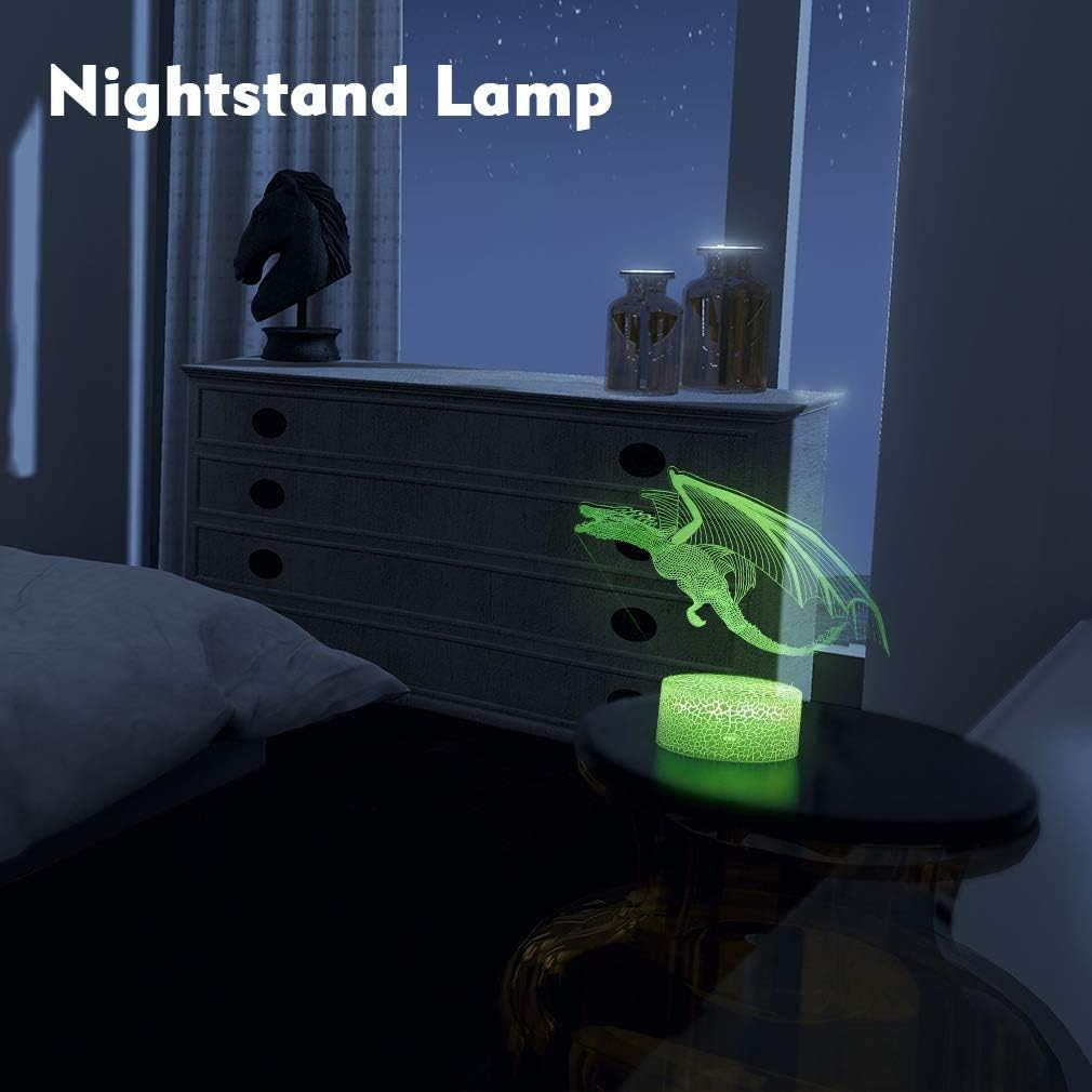 Eine grüne Drachen-Nachtischlampe leuchtet auf einem Tisch in einem dunklen Schlafzimmer.
