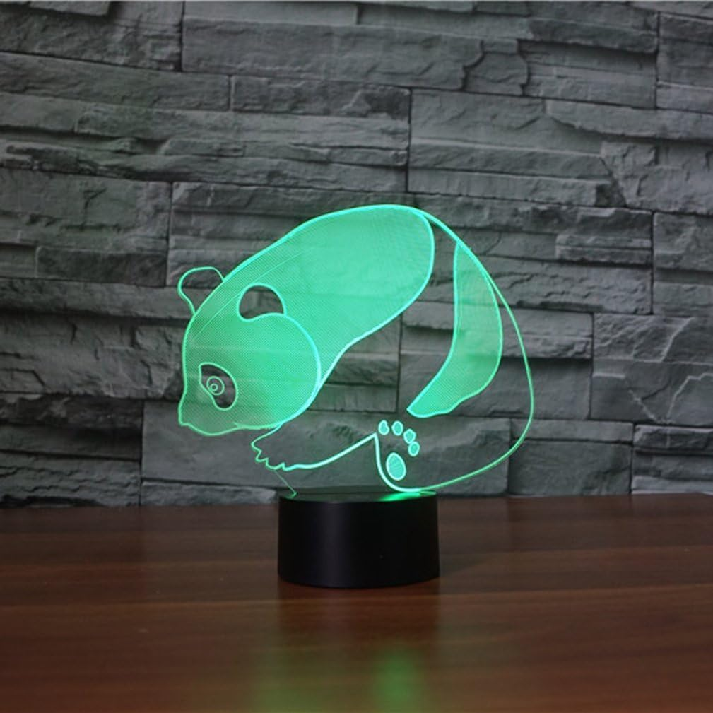 Eine leuchtend grüne 3D-Acryllampe in Pandaform steht auf einer Holzoberfläche vor einer grauen Steinwand.