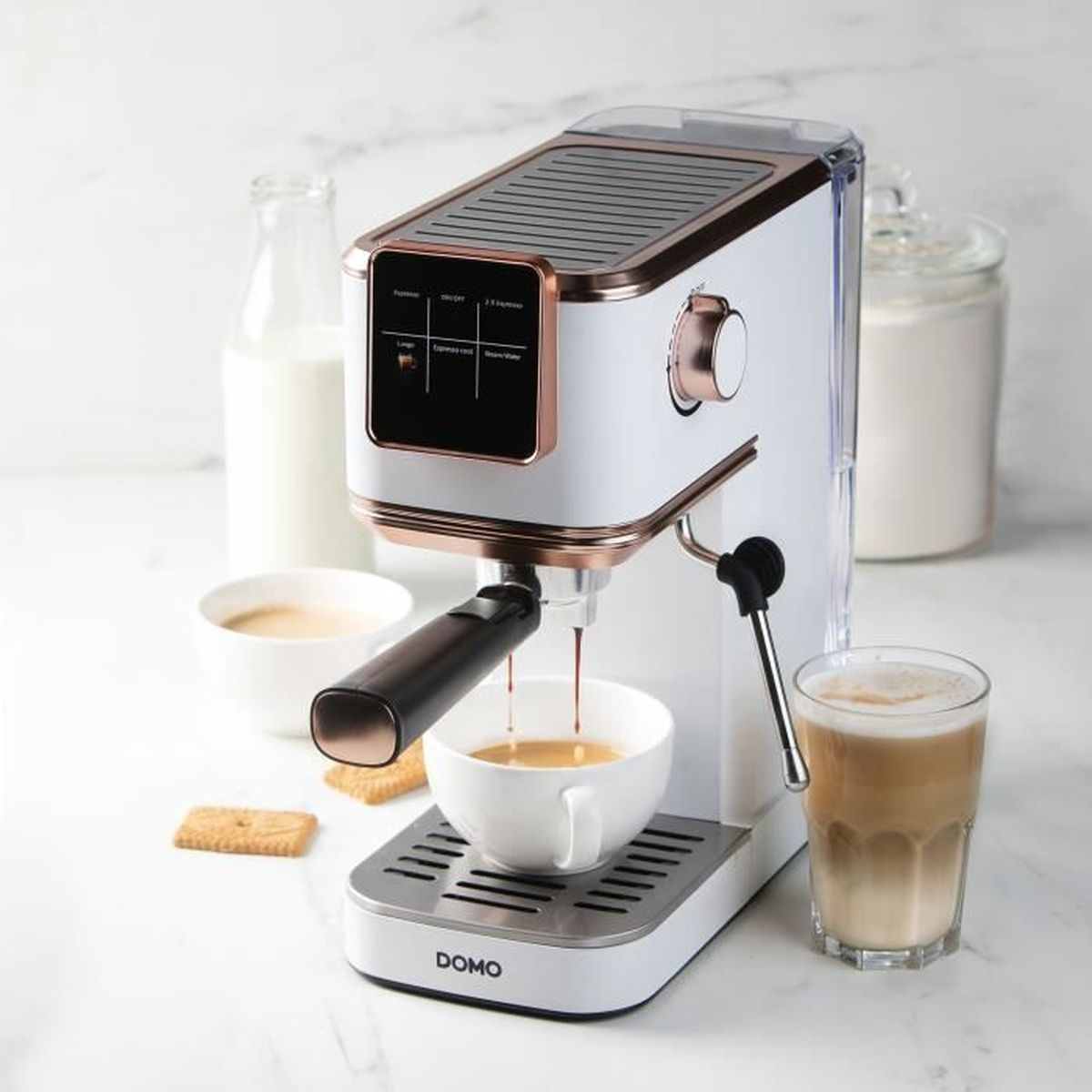 Une machine à expresso DOMO blanche et or rose verse du café dans une tasse sur un comptoir en marbre.