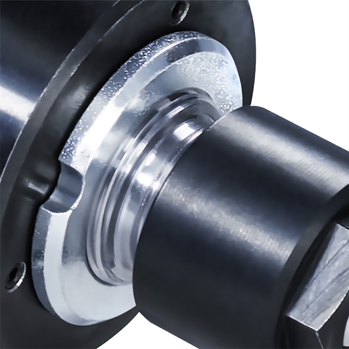 Nahaufnahme von mechanischen Teilen, einschließlich schwarzem Metall und einer silbernen Unterlegscheibe.