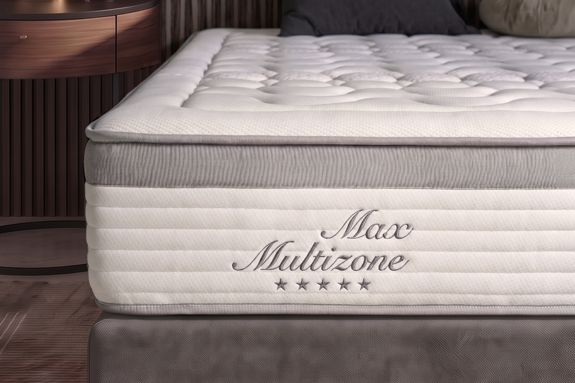 Közelkép egy fehér Max Multizone matracról, steppelt felülettel és szürke oldalsó panellel.