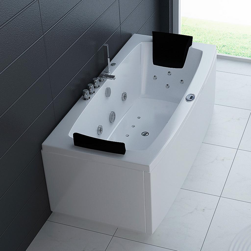 Eine weiße Badewanne mit schwarzen Kopfstützen und Chromarmaturen steht vor dunklen Fliesen.