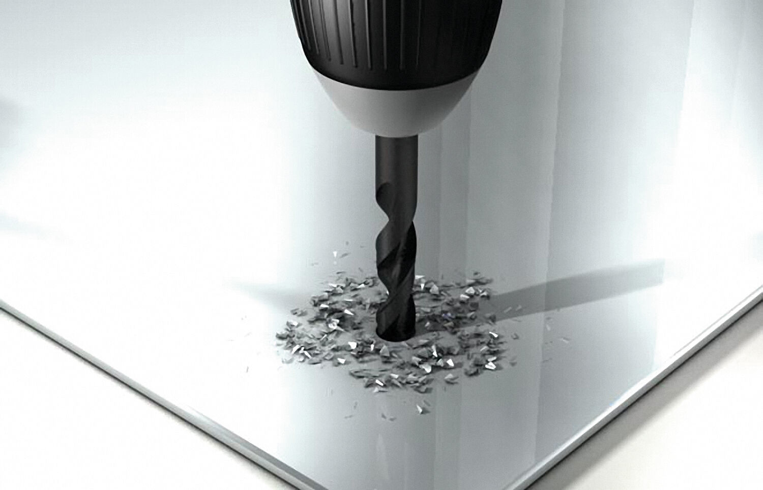 Eine Bohrmaschine bohrt ein Loch in ein glänzendes Metallblech, umgeben von kleinen Spänen.
