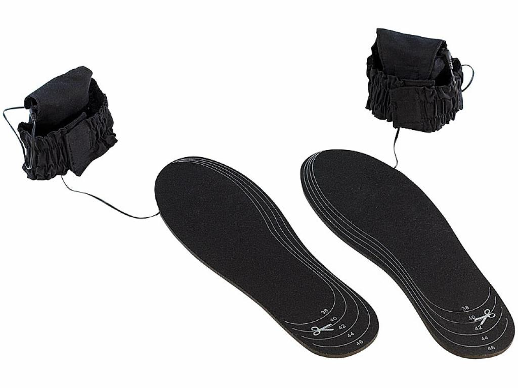 Beige schwarze beheizbare Einlegesohlen mit Akku-Halterungen auf weißem Grund.
