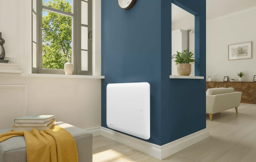 Ein weißer Elektroheizer ist an einer dunkelblauen Wand in einem hellen, modernen Wohnzimmer montiert.