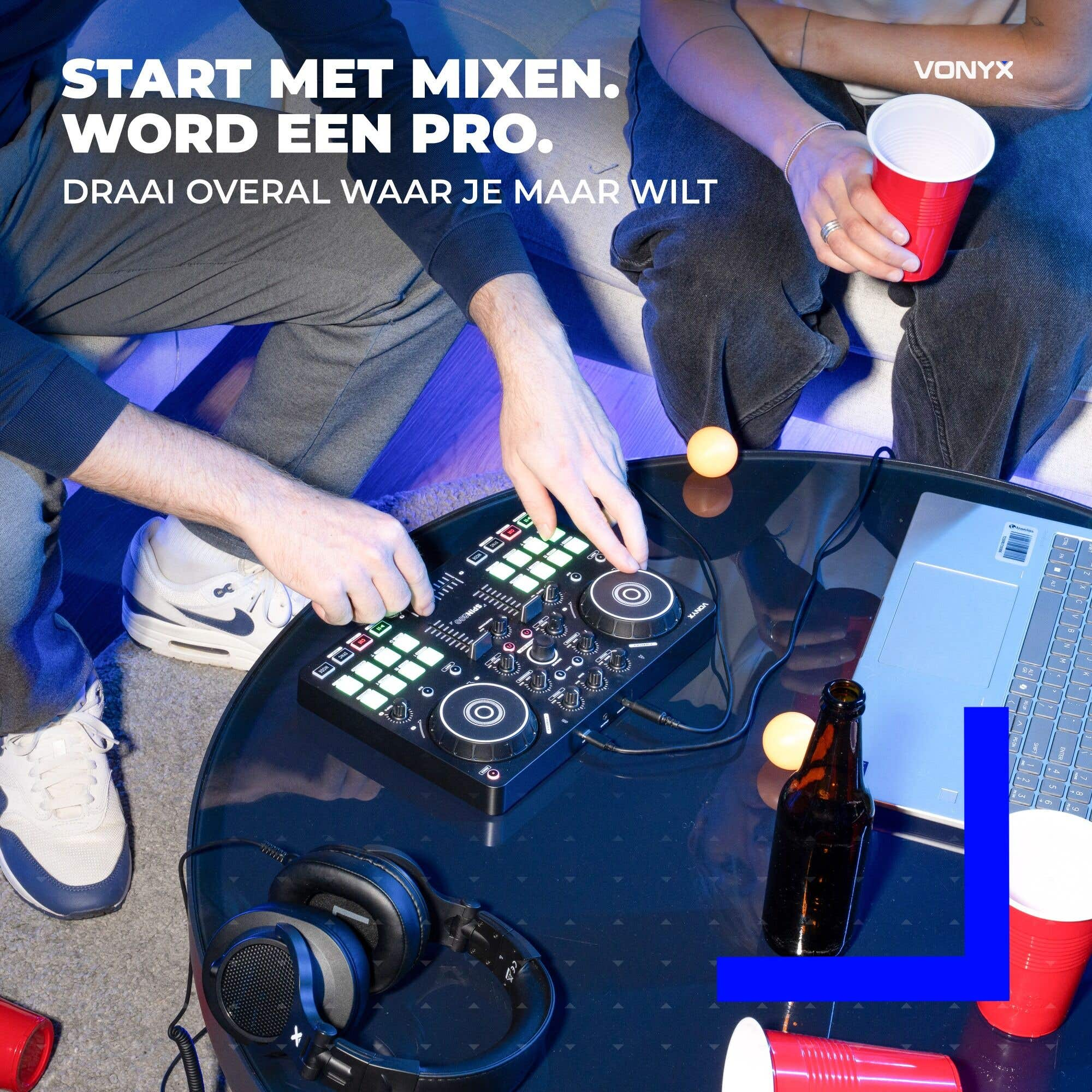 Eine Person benutzt einen DJ-Controller auf einem Glastisch mit Laptop, Getränken und Kopfhörern.