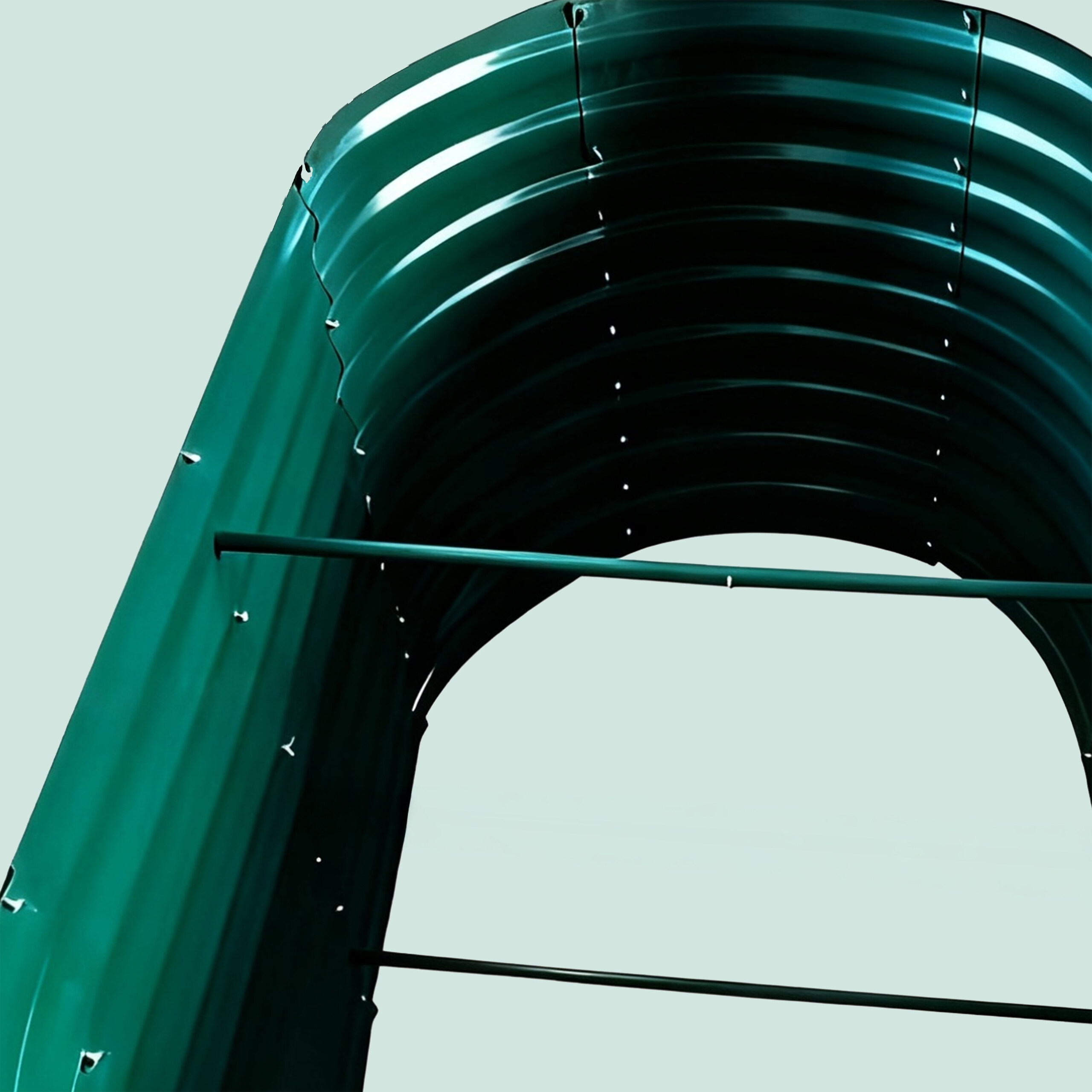 Ein grünes Metallbogensegment mit Verstrebungen vor hellgrauem Hintergrund.