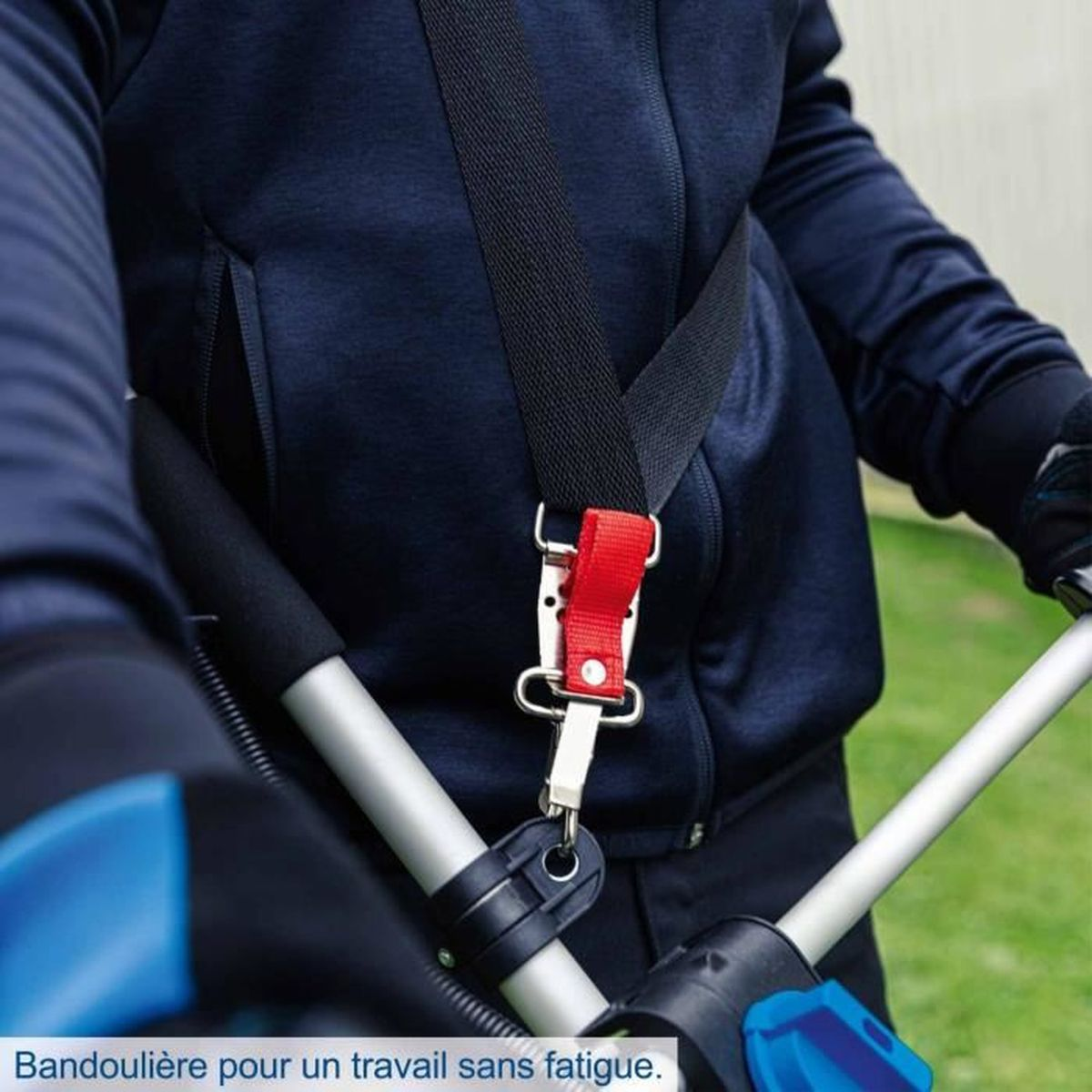 Eine Person in blauer Jacke trägt einen schwarzen Gurt, der per rotem Verschluss am Trimmer befestigt ist.
