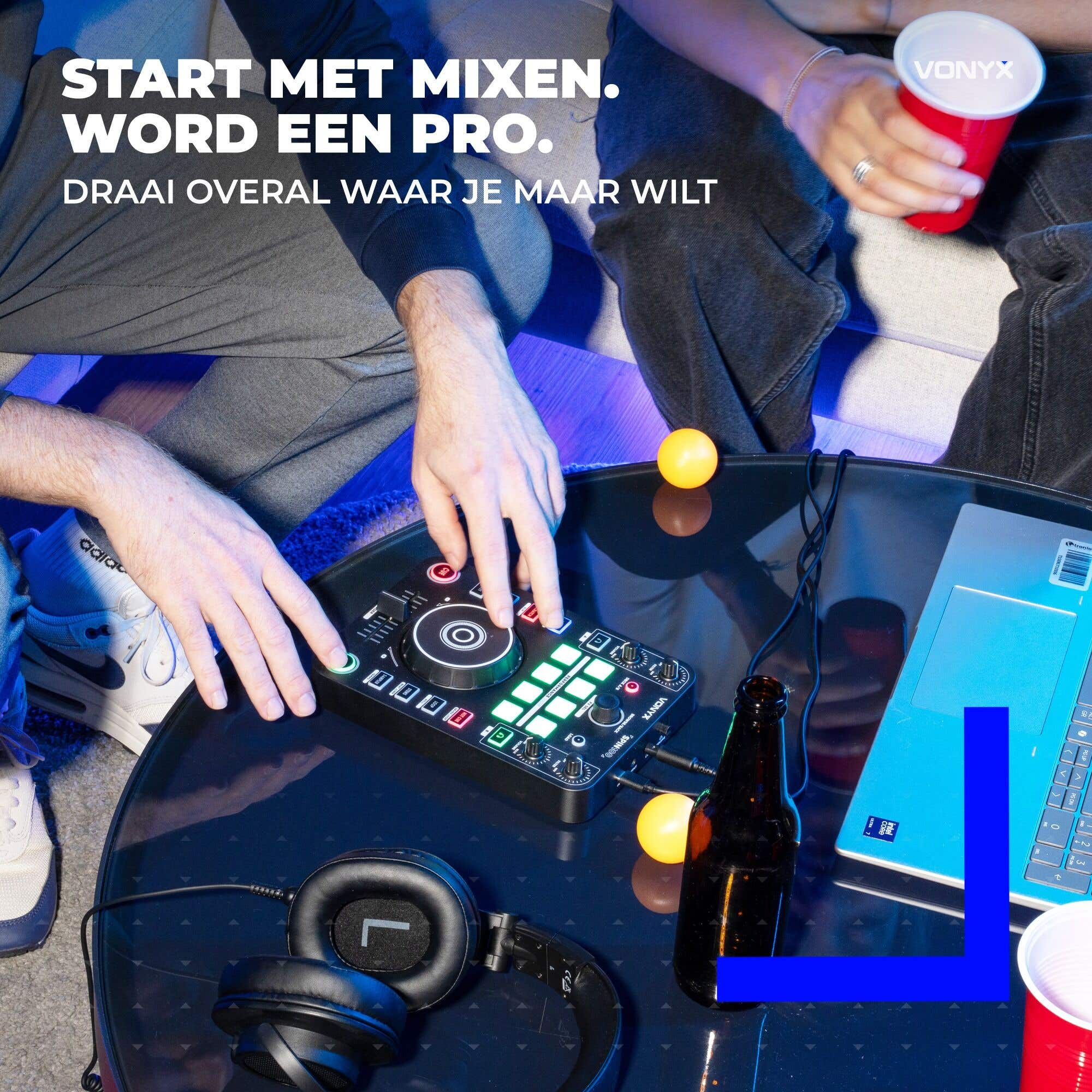 Zwei Personen mixen Musik auf einem DJ-Controller an einem Couchtisch mit Laptop, Kopfhörern und Getränken.