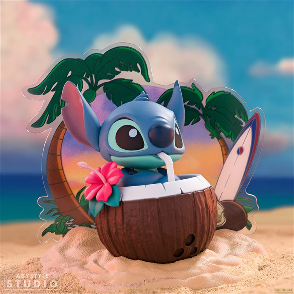 Stitch sitzt in einer Kokosnuss mit Strohhalm, Blume und Surfbrett vor Strandkulisse.