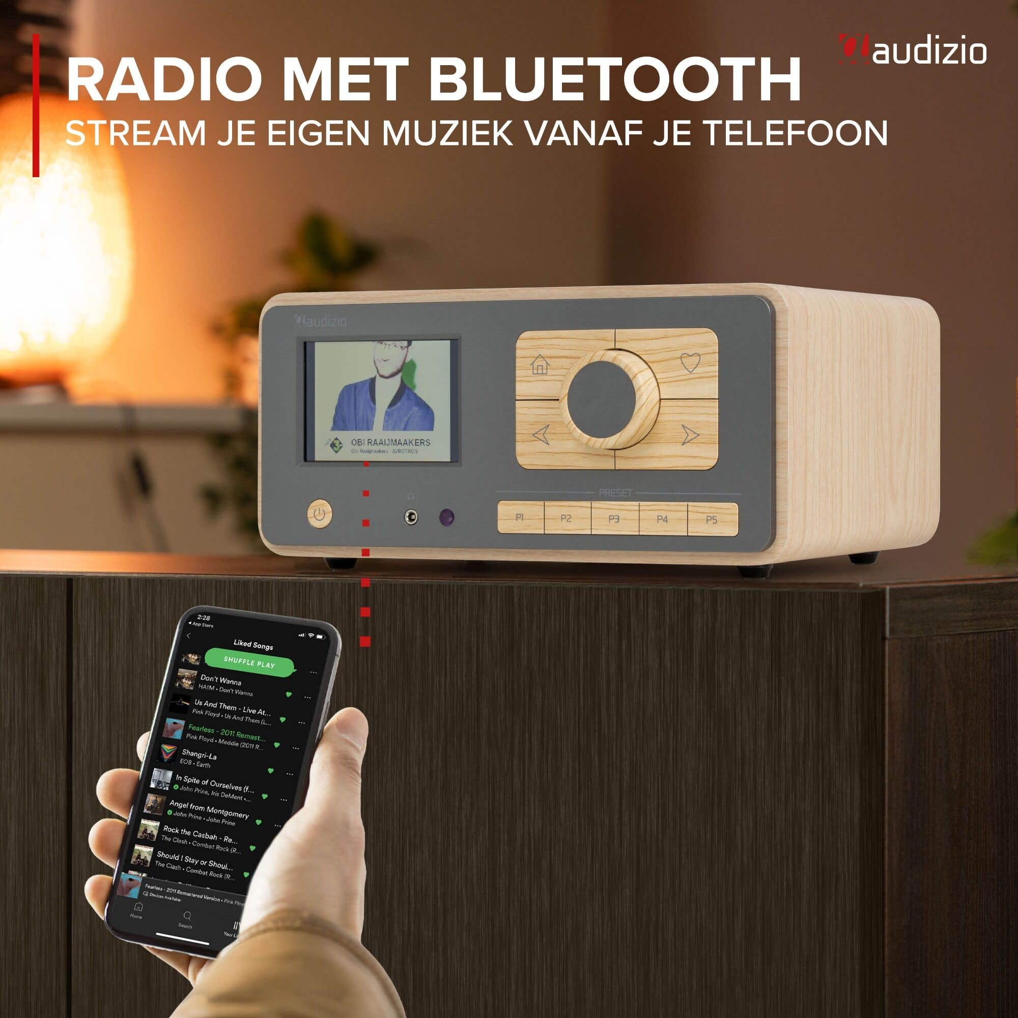Holzfarbenes Audizio-Radio mit Bluetooth auf Schrank, Smartphone im Vordergrund.