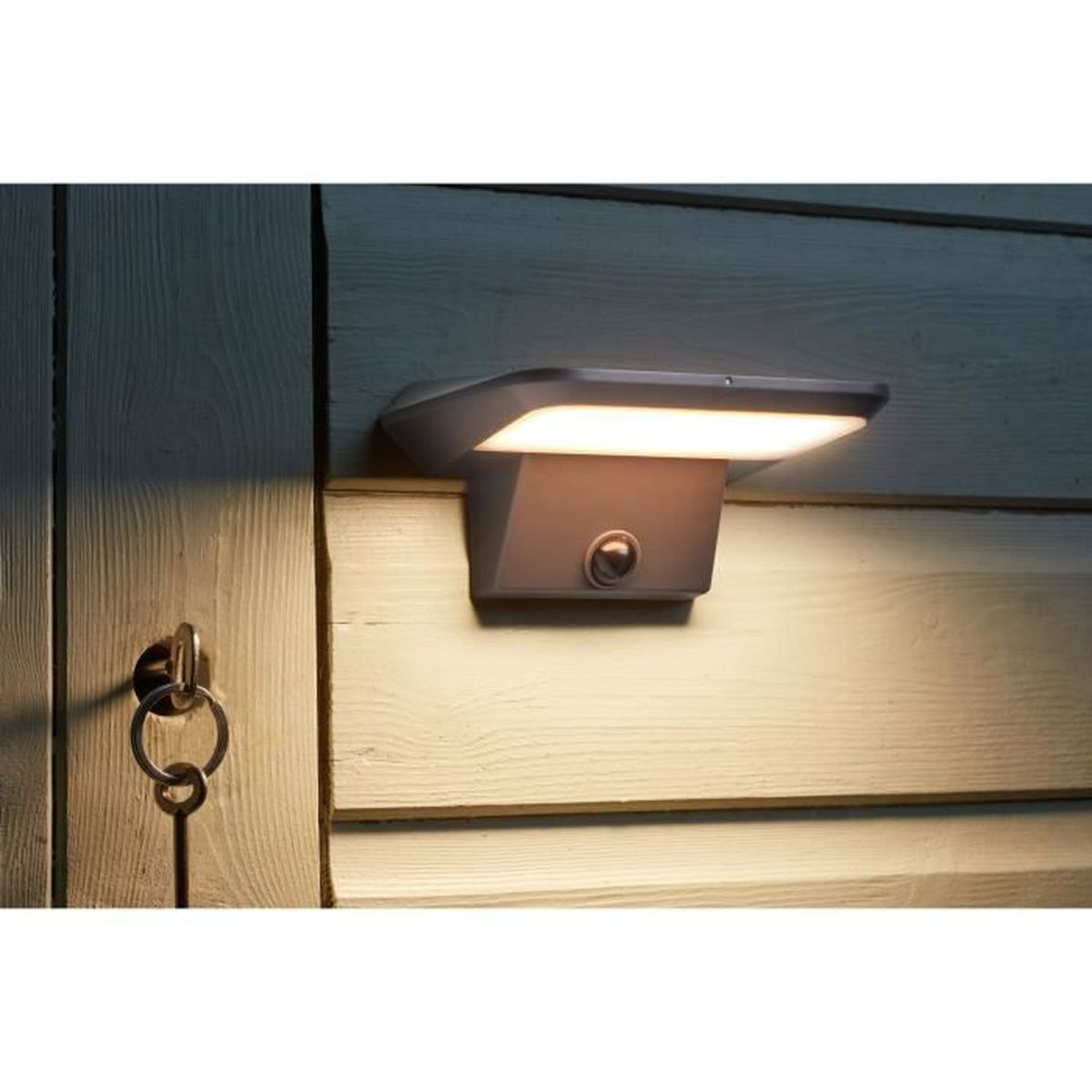 Eine moderne Außen-LED-Wandleuchte beleuchtet eine Holzwand neben einer Tür mit einem Schlüssel im Schloss.