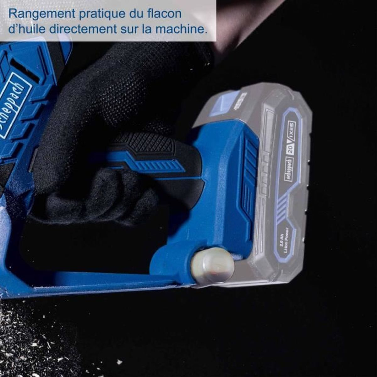 Eine behandschuhte Hand hält ein blau-graues Akku-Werkzeug vor dunklem Hintergrund, mit französischem Text oben.
