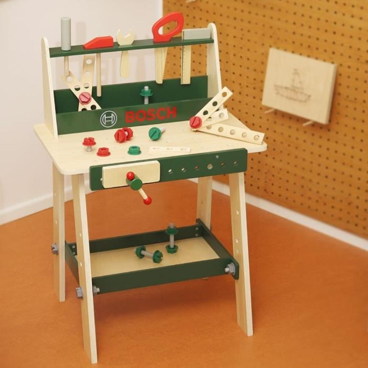 Eine hölzerne Spielzeug-Werkbank mit grünen Akzenten, Werkzeugen, Schrauben und dem Bosch-Logo.