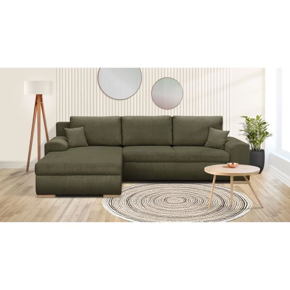 Ein grünes Ecksofa steht im Wohnzimmer mit Holzboden, rundem Teppich, kleinem Tisch und Lampe.