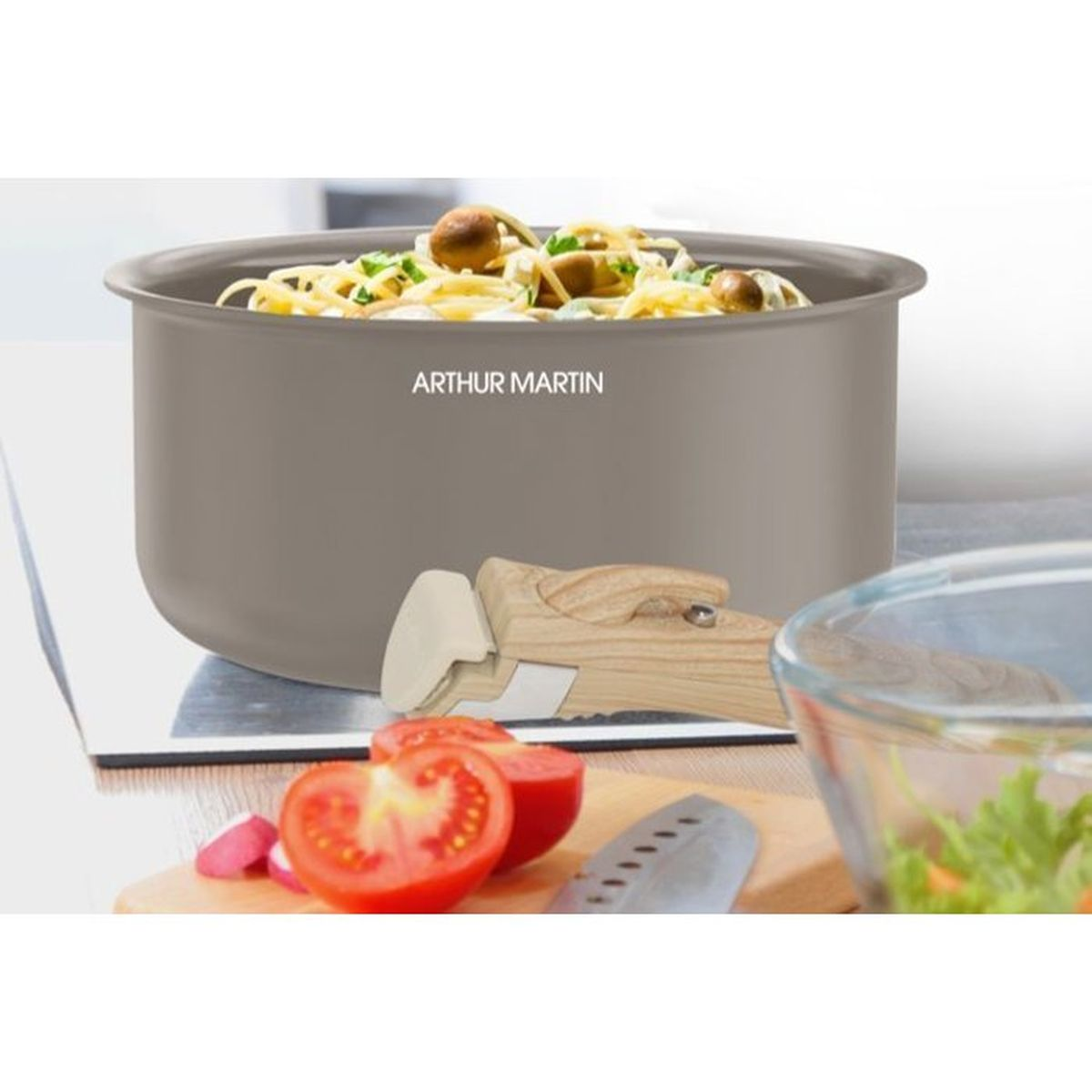 Eine graue Arthur Martin Pfanne mit Pasta, vorne Tomaten und ein Holzgriff.