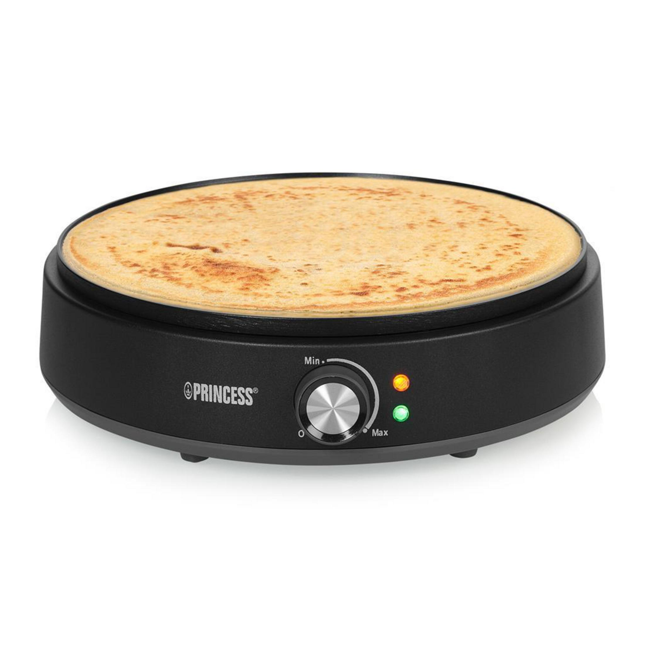 Una crepera eléctrica negra con una crepe dorada cocinándose en su plancha redonda antiadherente.