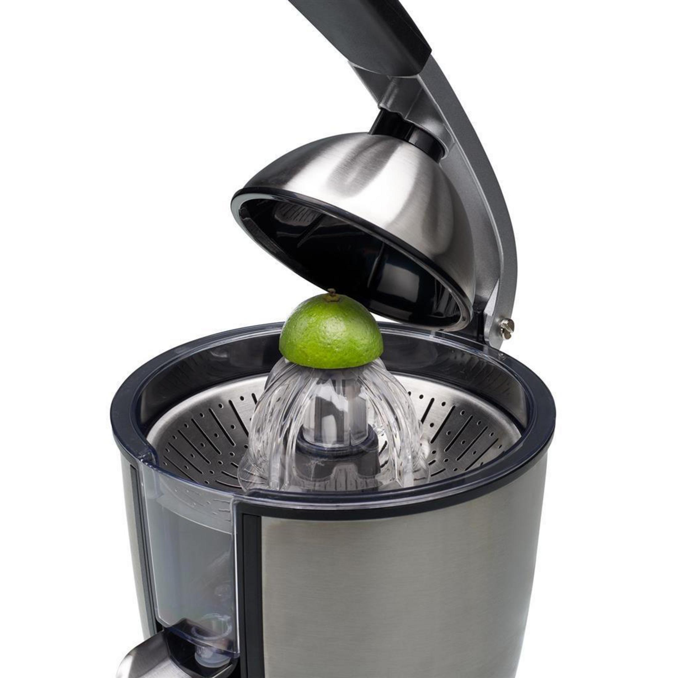 Uno spremiagrumi argento con la leva aperta e un lime verde sul cono.