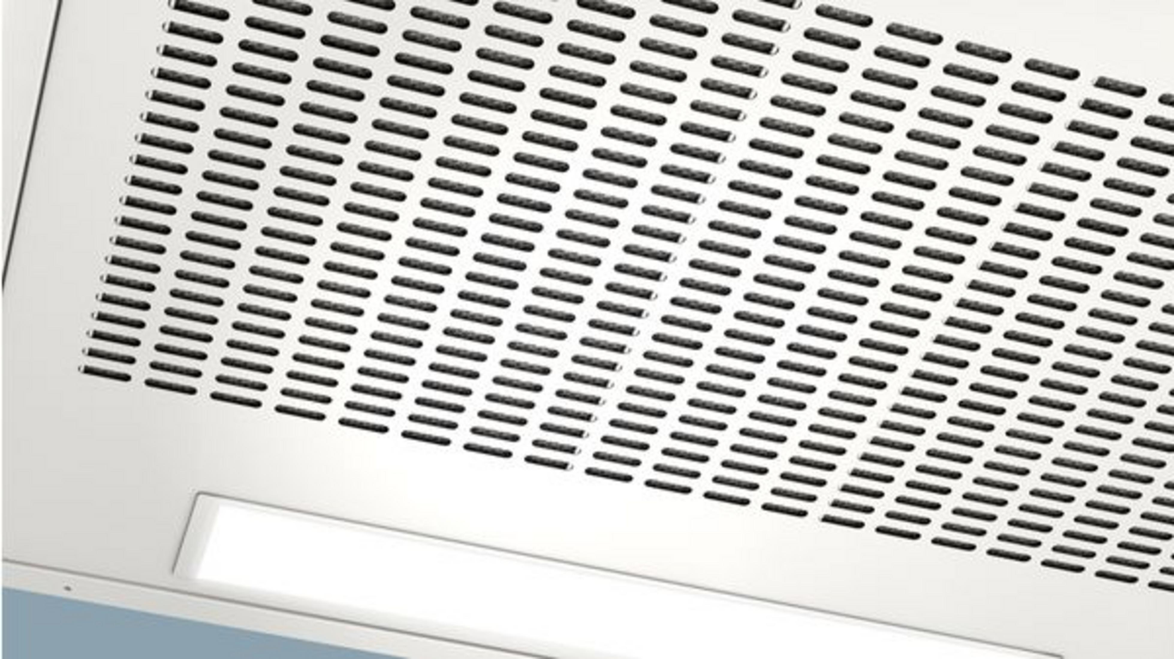 Parte inferior de una campana extractora blanca con finas ranuras de ventilación e iluminación integrada.