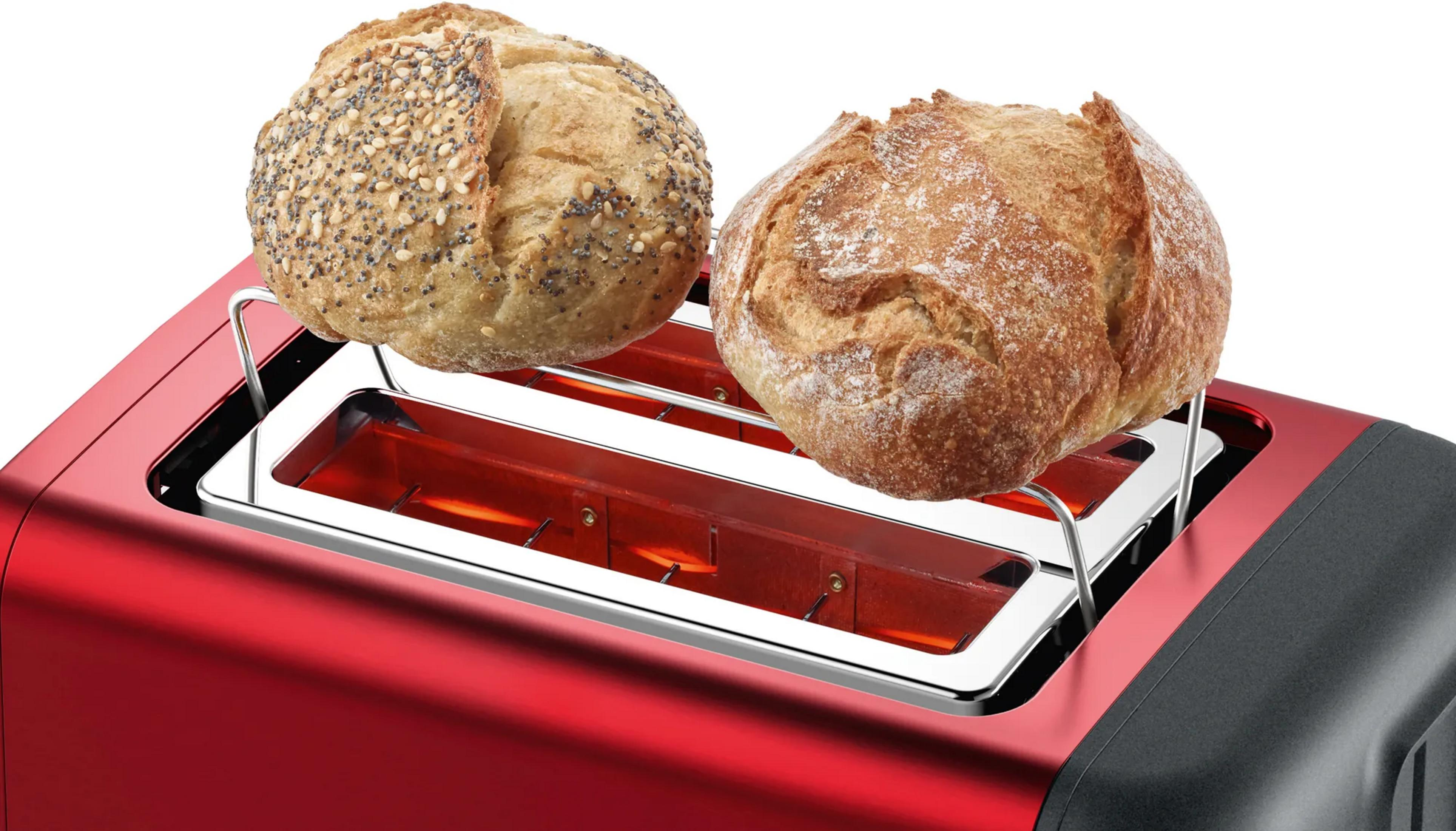Zwei runde Brotlaibe auf einem Aufsatz über den glühenden Schlitzen eines roten Toasters.