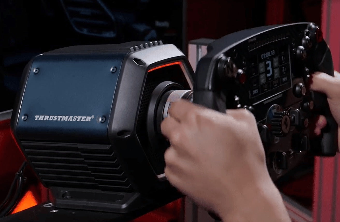Manos sosteniendo un volante de carreras Thrustmaster con pantalla digital en la base.