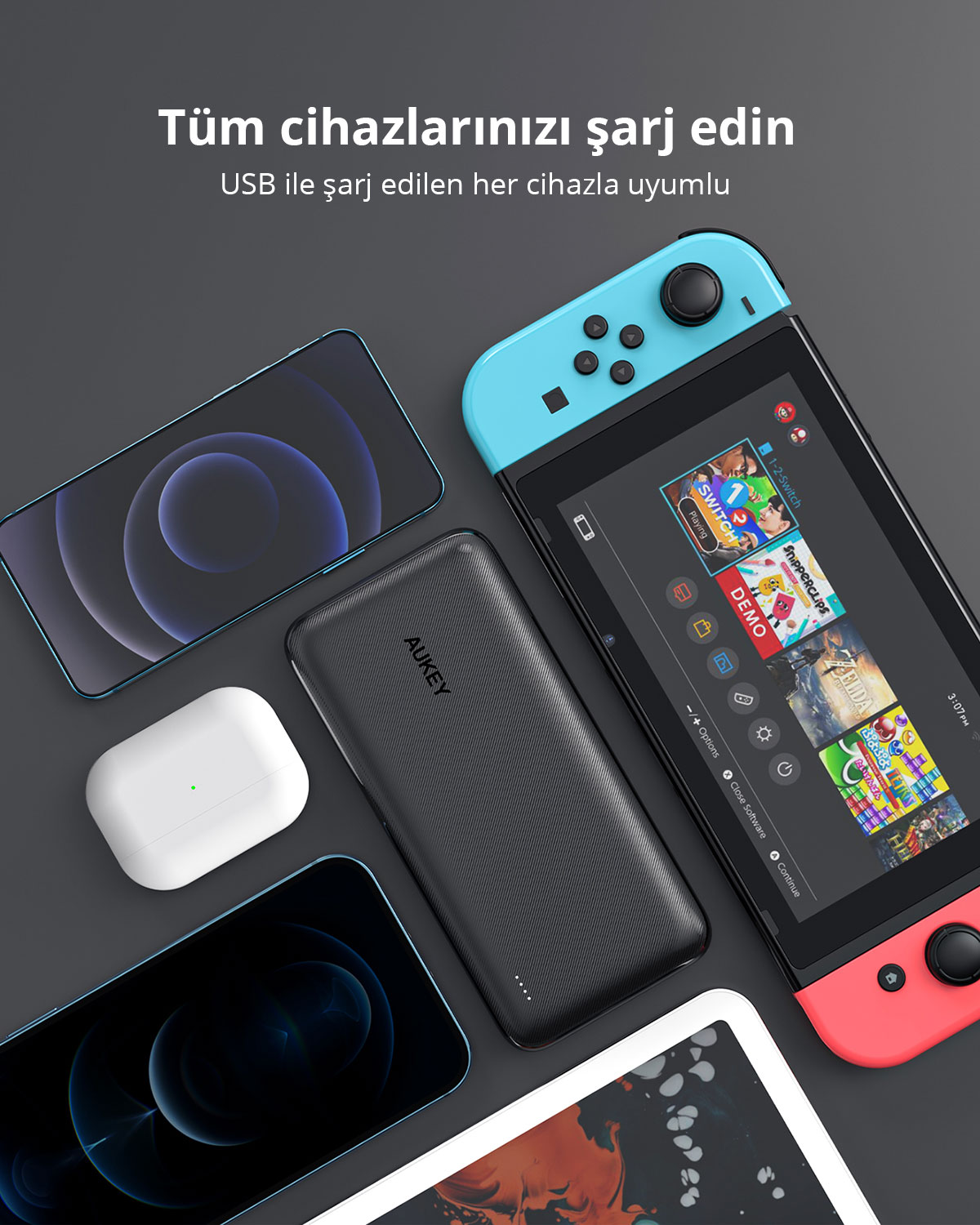 Gri zemin üzerinde iki akıllı telefon, kablosuz kulaklık, oyun konsolu ve tablet ile çevrili siyah bir taşınabilir şarj cihazı.