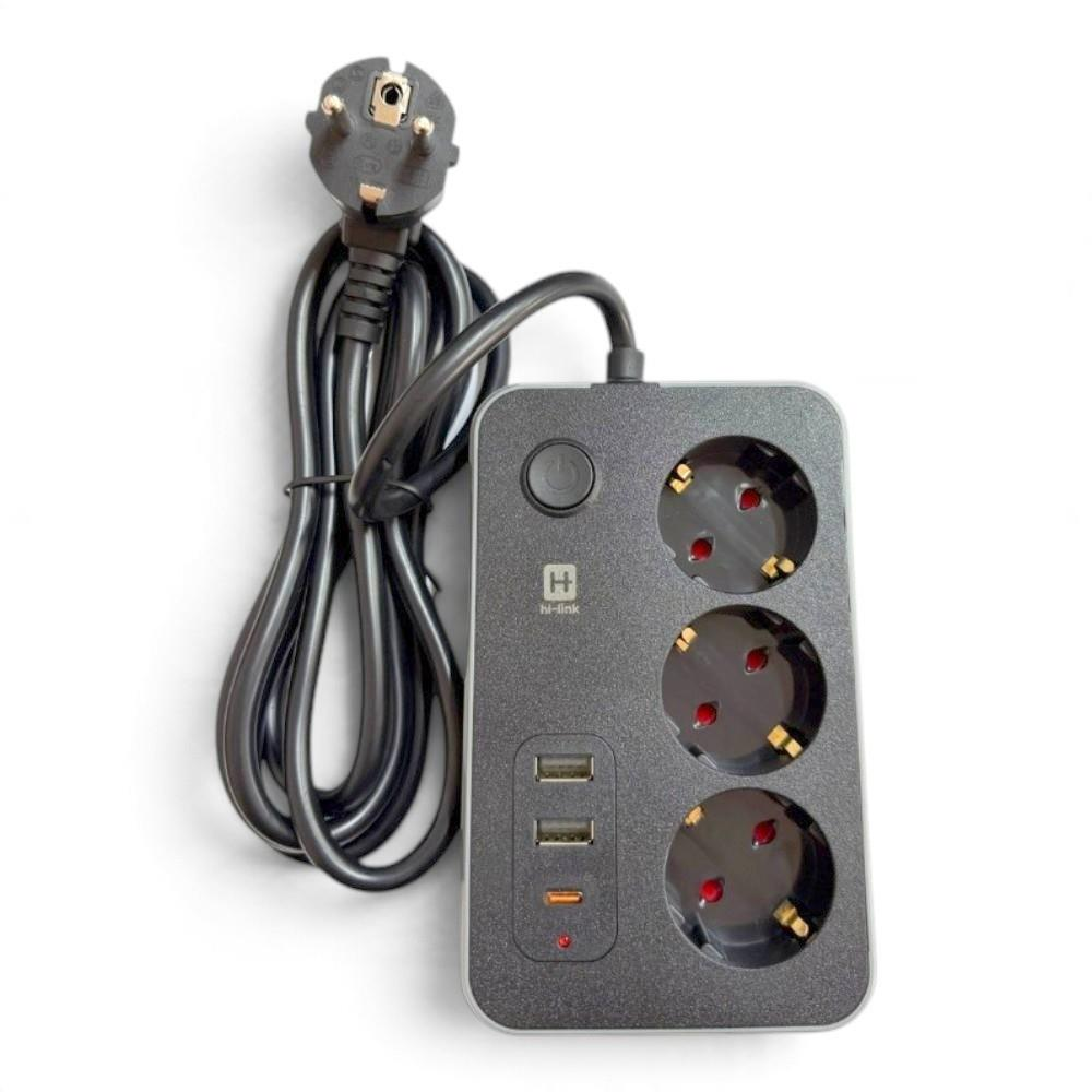 Beyaz zemin üzerinde üç priz, üç USB bağlantı noktası, anahtar ve siyah kabloya sahip gri bir uzatma kablosu.