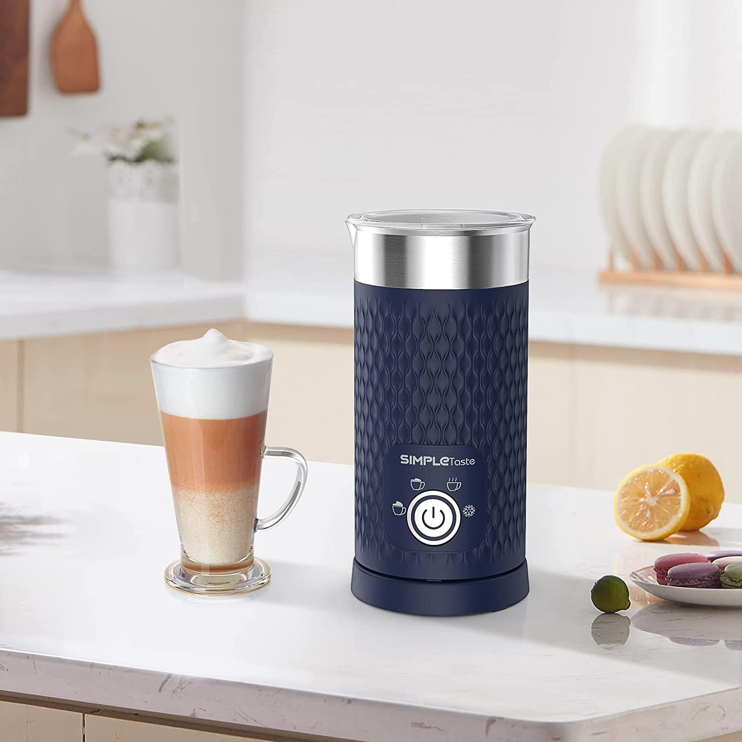 Mousseur à lait bleu sur un comptoir avec une tasse de cappuccino et des citrons.