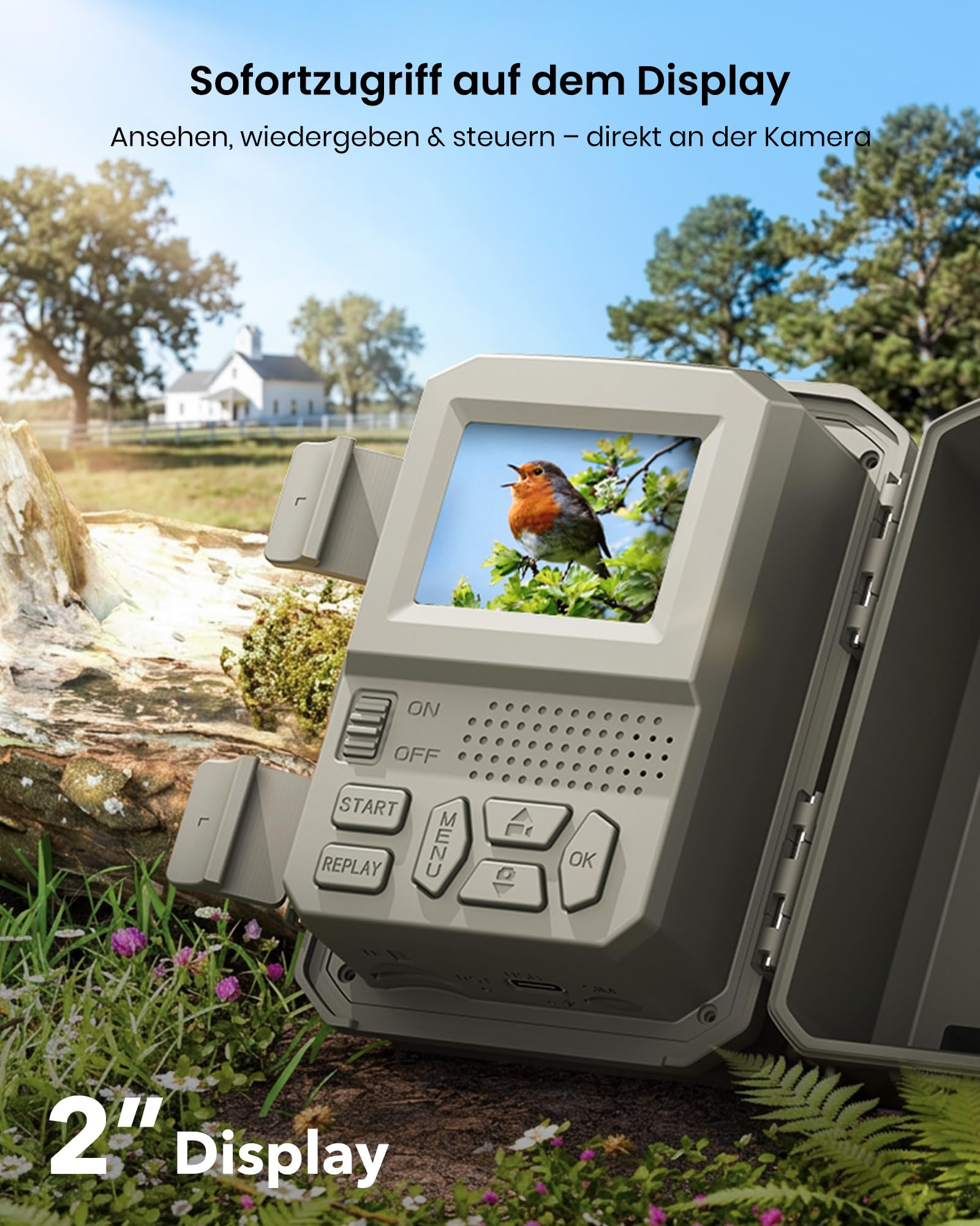 Wildkamera mit offenem Display im Wald zeigt einen Vogel, davor ein Baumstamm und grüne Wiese.