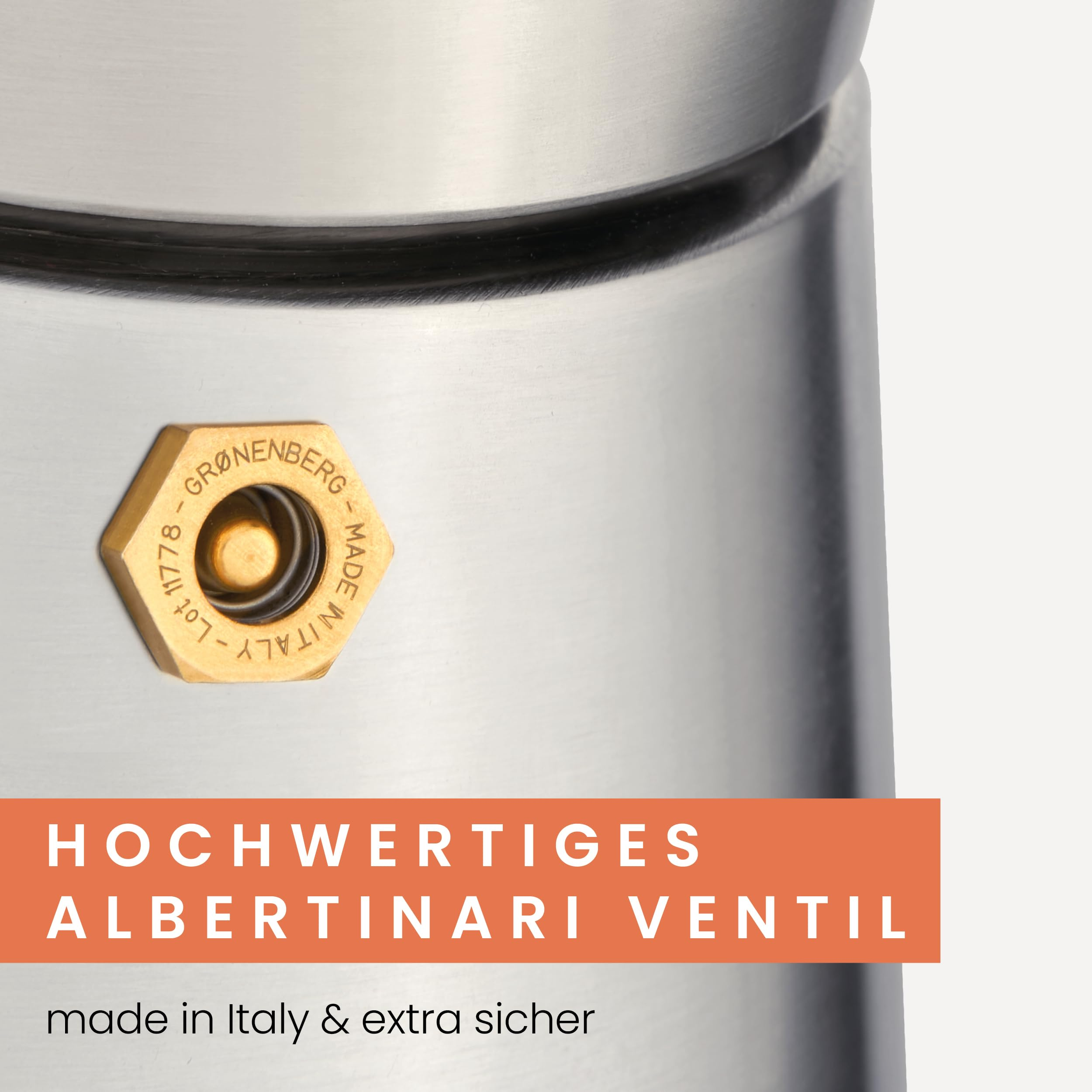 Gros plan d'une valve dorée sur une cafetière argentée sur fond blanc.