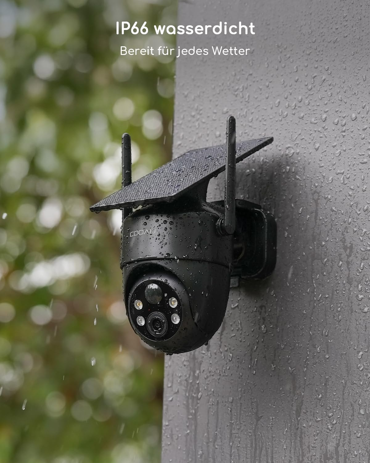 Una telecamera di sicurezza nera con pannello solare è montata su un muro bagnato durante la pioggia.
