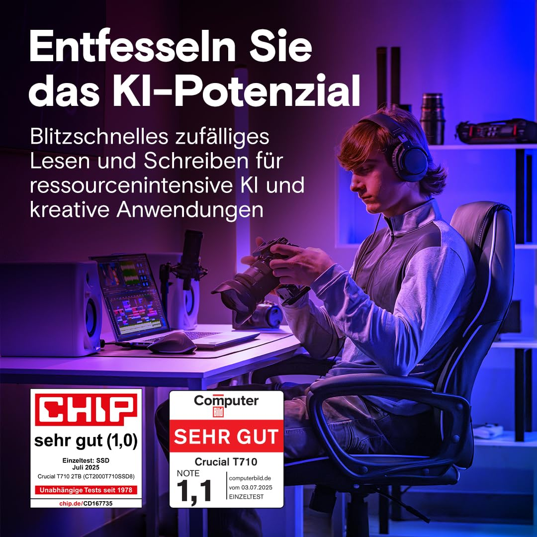 Eine Person mit Kopfhoerern sitzt am Schreibtisch mit Laptop und Kamera in einem blauen und lila beleuchteten Raum.