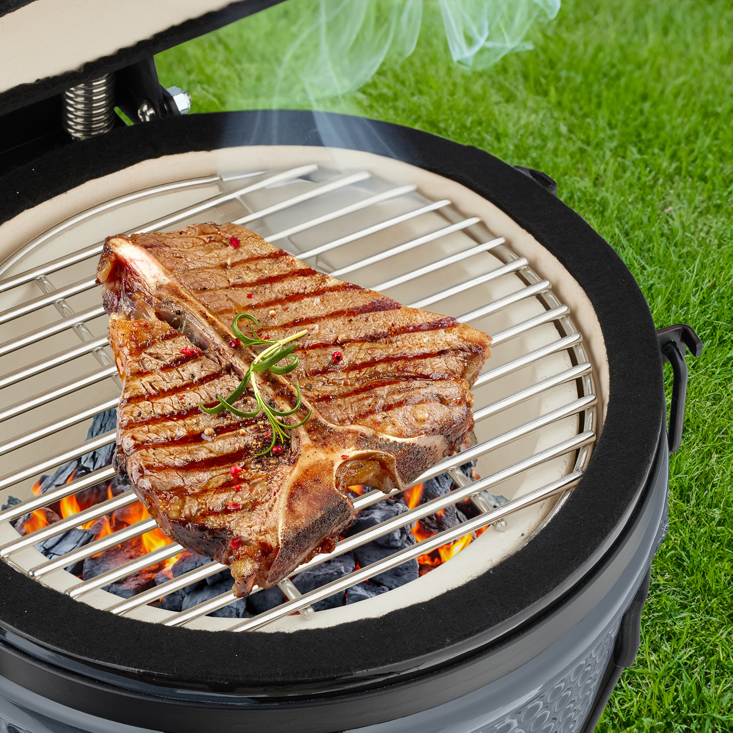 Ein saftiges T-Bone-Steak mit Rosmarin wird auf einem Holzkohlegrill über glühenden Kohlen gegrillt.
